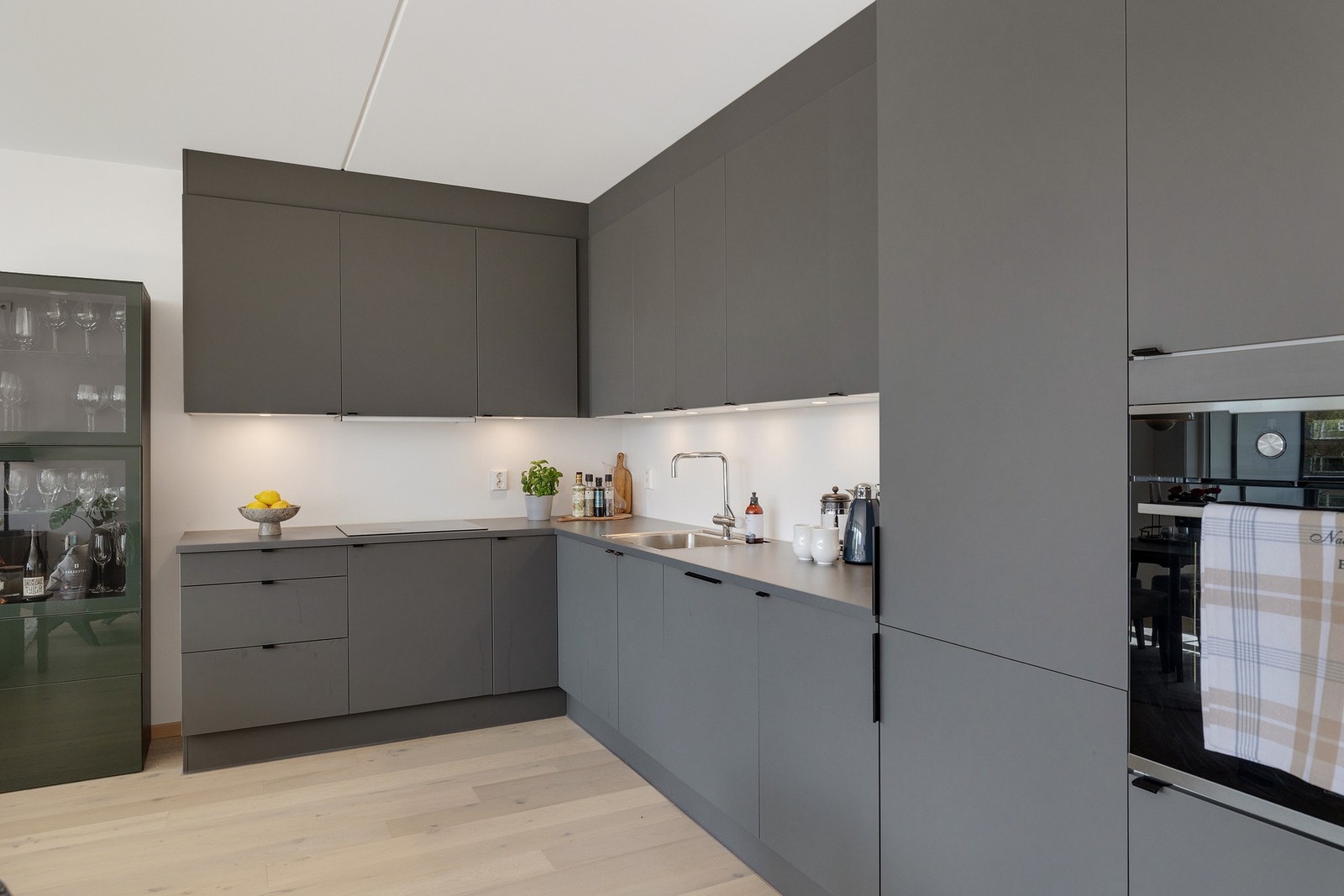 Kjøkkenet har integrerte hvitevarer med oppvaskmaskin, kjøl/frys, komfyr og platetopp Galleribilde