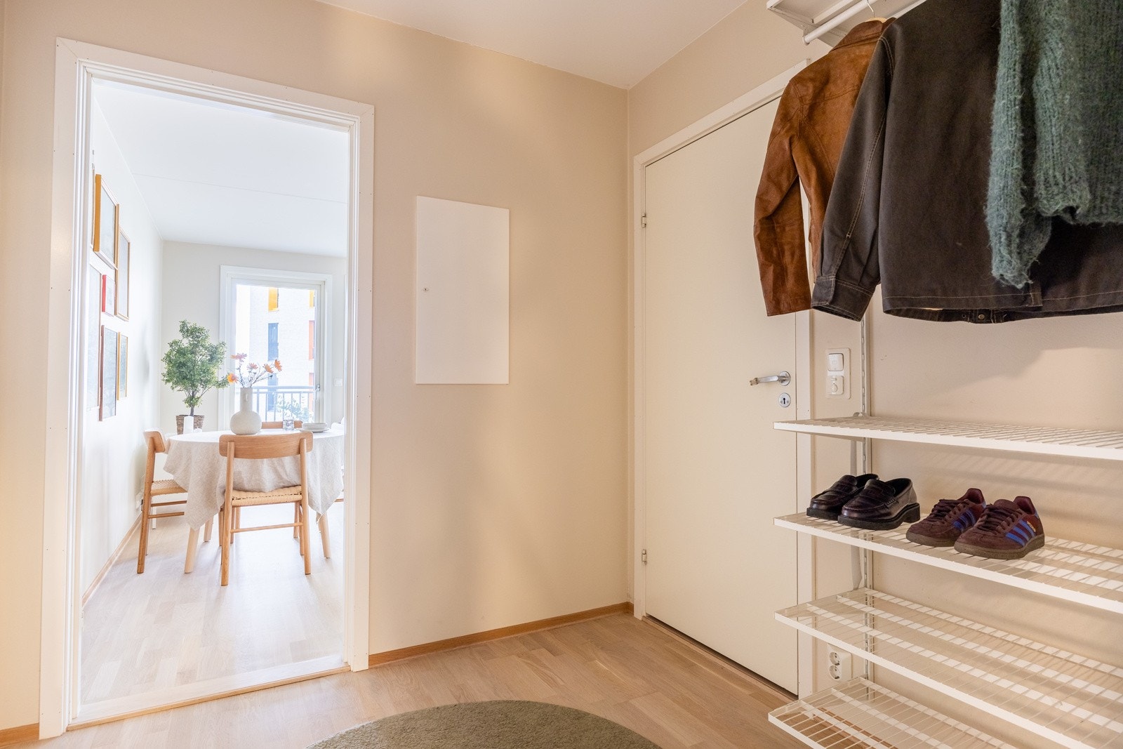 Lys entré med plass til oppheng av yttertøy og oppbevaring av sko. Galleribilde