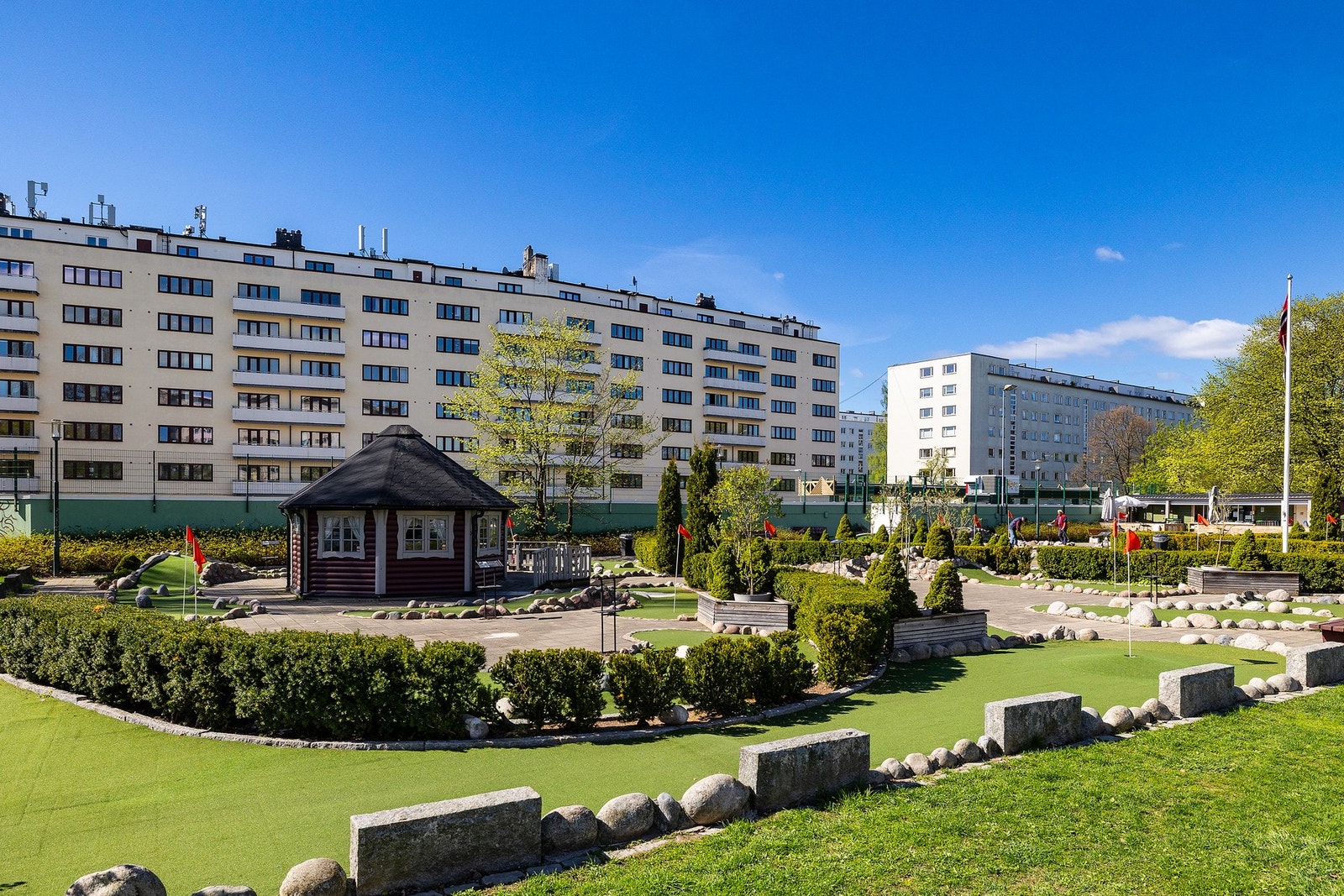 Rett over gaten ligger Marienlystparken med minigolf, lekeapparater, sittegrupper m.m. Galleribilde