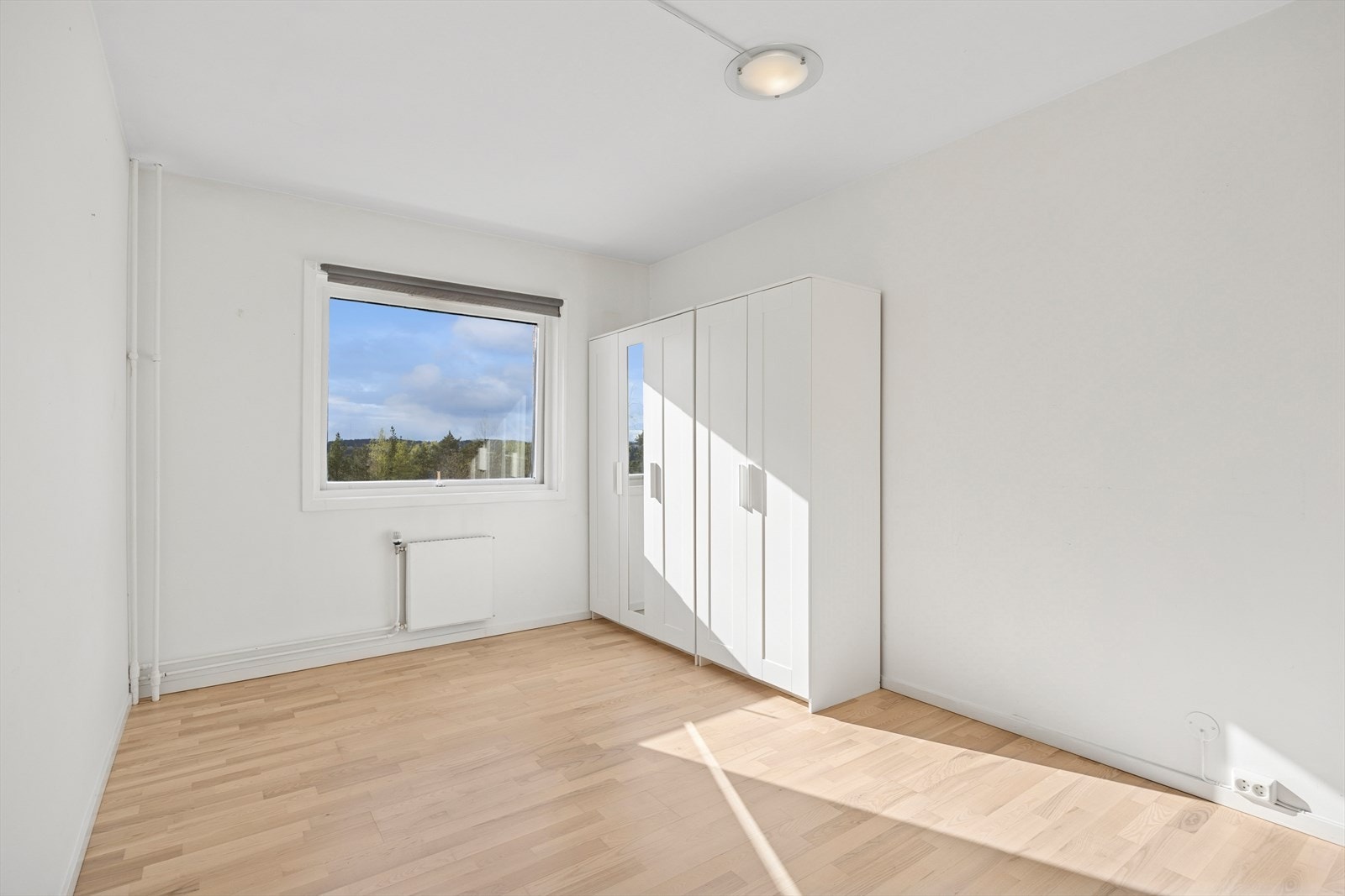 Romslig soverom med plass til dobbeltseng, nattbord og garderobeskap - en perfekt kombinasjon av komfort og oppbevaring. Fin utsikt her også! Galleribilde