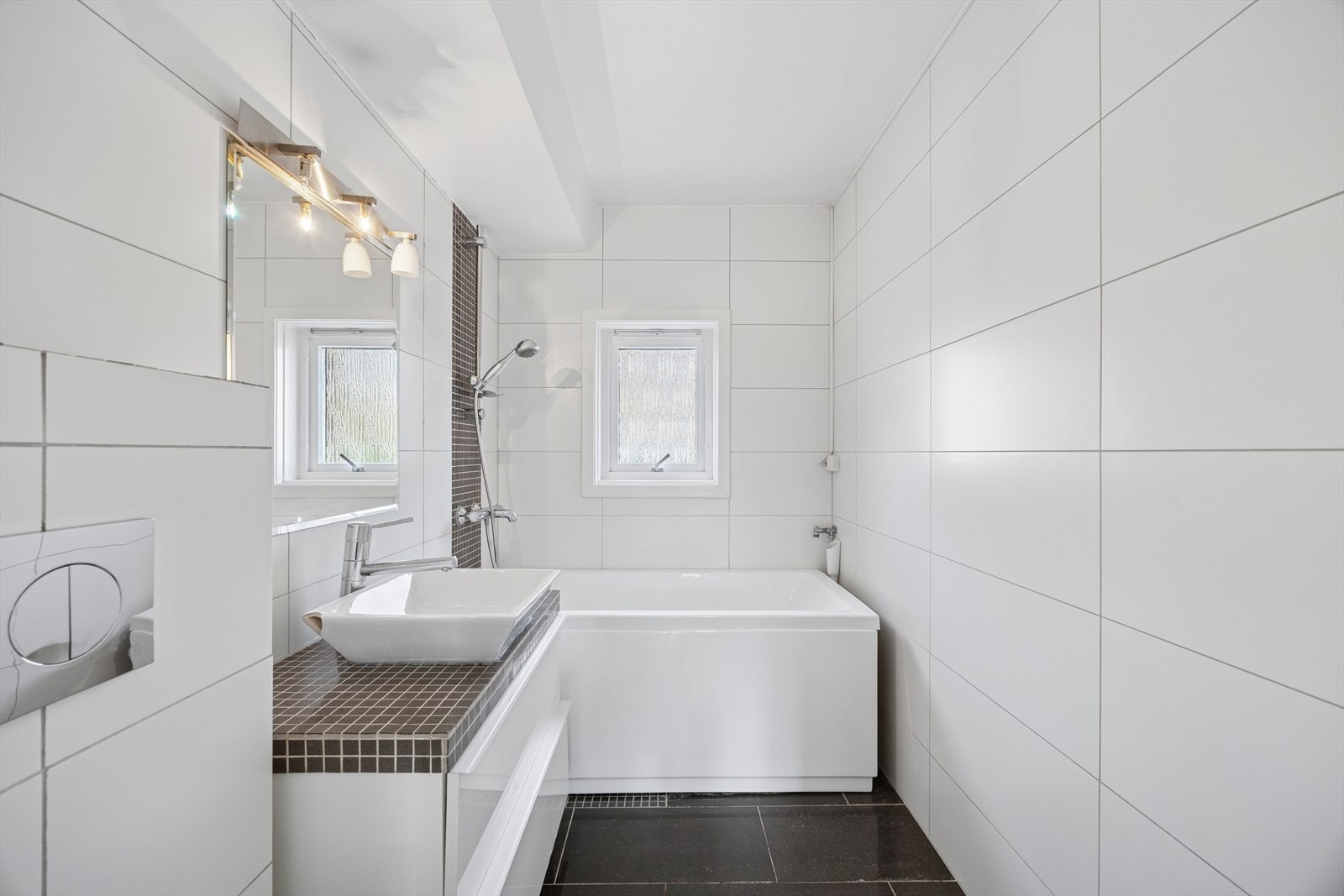 Pent bad fra 2011 med flislagte vegger og gulv, samt malt himling - en tidløs og funksjonell løsning. Galleribilde