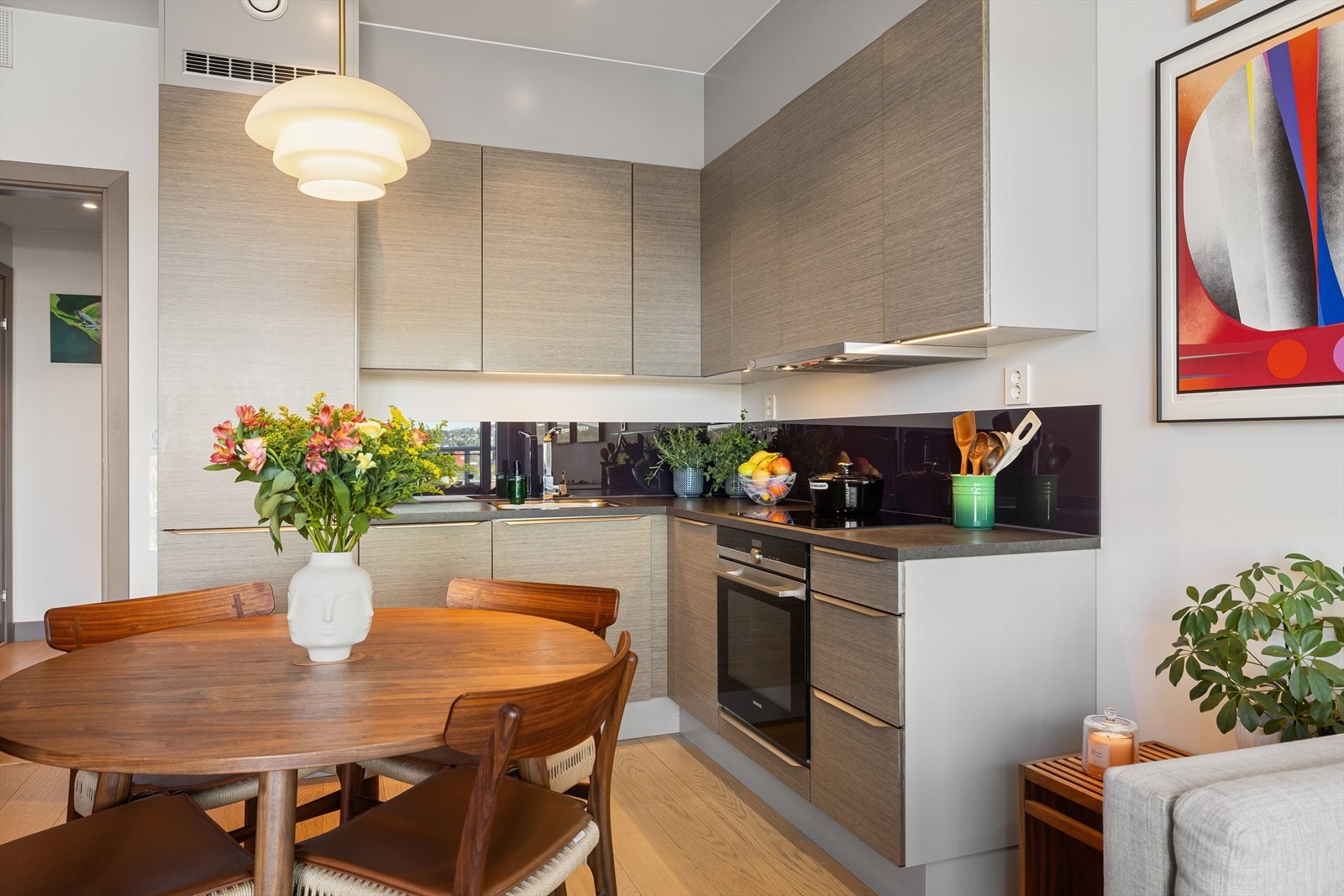 Moderne og stilsikkert kjøkken med skjermet plassering. Tidsriktig kjøkken fra HTH med glatte fronter og benkeplate i laminat. Galleribilde