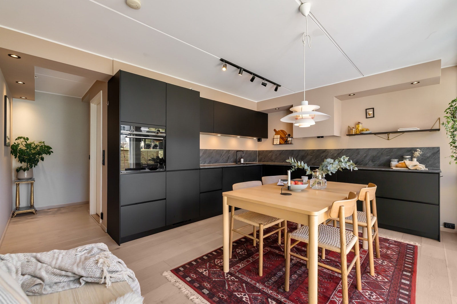 Kjøkkeninnredningen er moderne og elegant med benkeplate i laminat, underlimt oppvaskkum og ett-greps armatur i sort utførelse Galleribilde