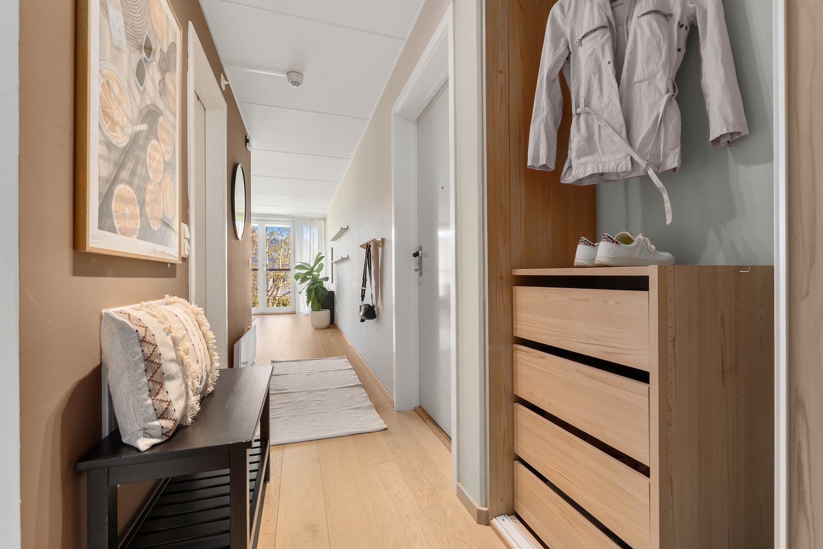 Lysmalt og romslig entré/gang med god plass til oppbevaringsmøbel, samt god lagringskapasitet i romslig skyvedrøsgarderobe Galleribilde