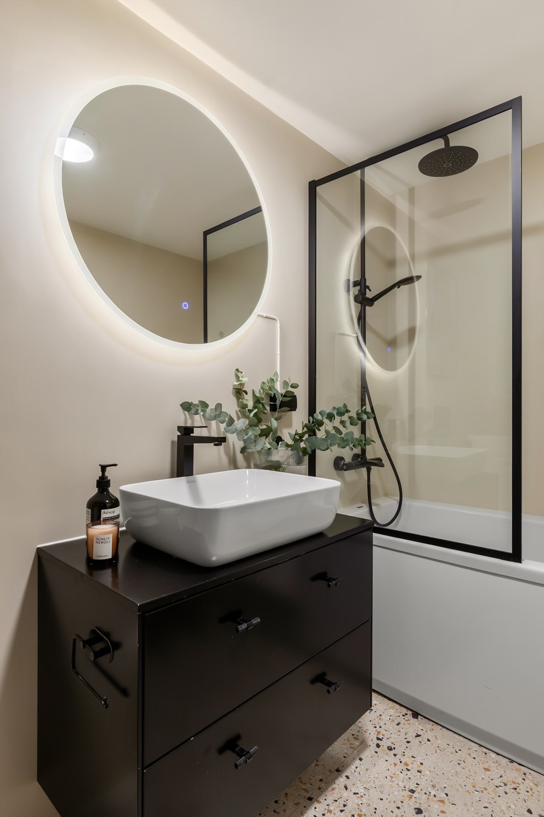 Baderommet innredet med badekar med glassvegg og dusjsett med rainshower, begge i sort utførelse Galleribilde