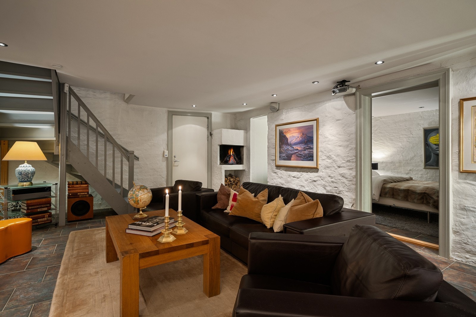 I hjørnet av kjellerstuen er det innfelt en åpen peis med vednisje under, og det er god plass til en romslig sofa- og TV-løsning eller hjemmekino. Galleribilde