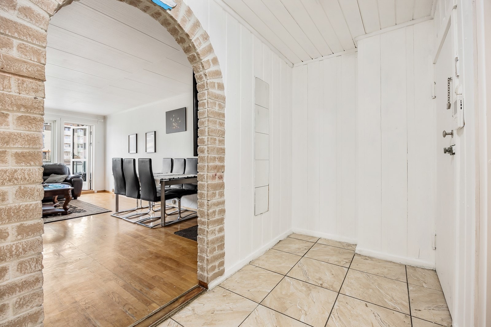 Velkommen inn! Fra byggets felles trapperom kommer man inn i en lys og flislagt entré/gang. Galleribilde