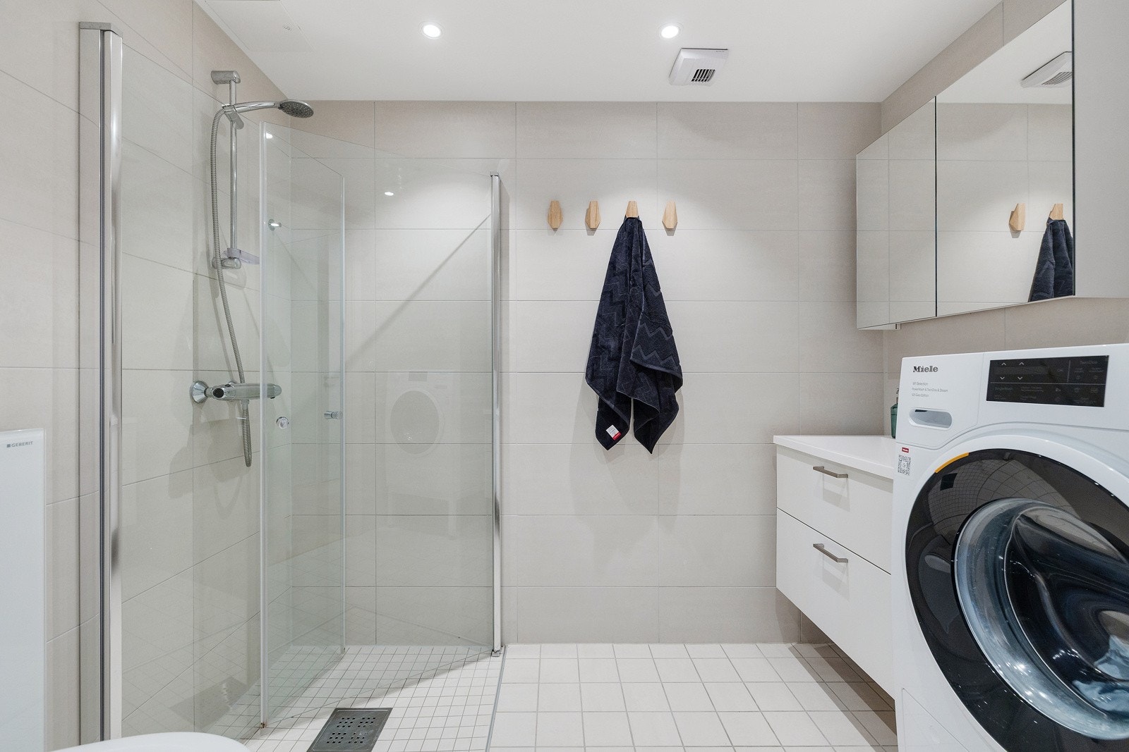 Lyst og moderne bad fra 2020 med opplegg for vaskemaskin. Galleribilde