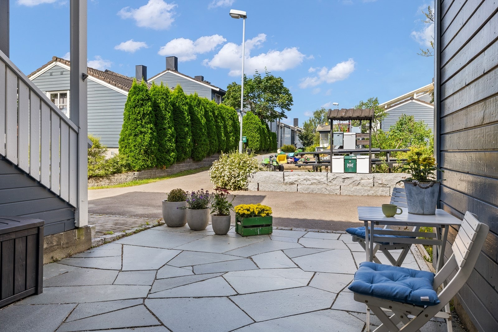 Flott skiferbelagt inngangsparti med rom for sittegruppe Galleribilde