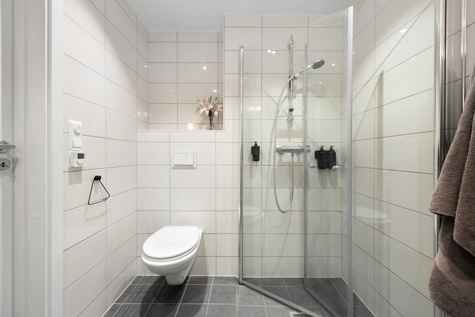 Det er dusjhjørne med innfellbare glassdører og vegghengt toalett. Galleribilde