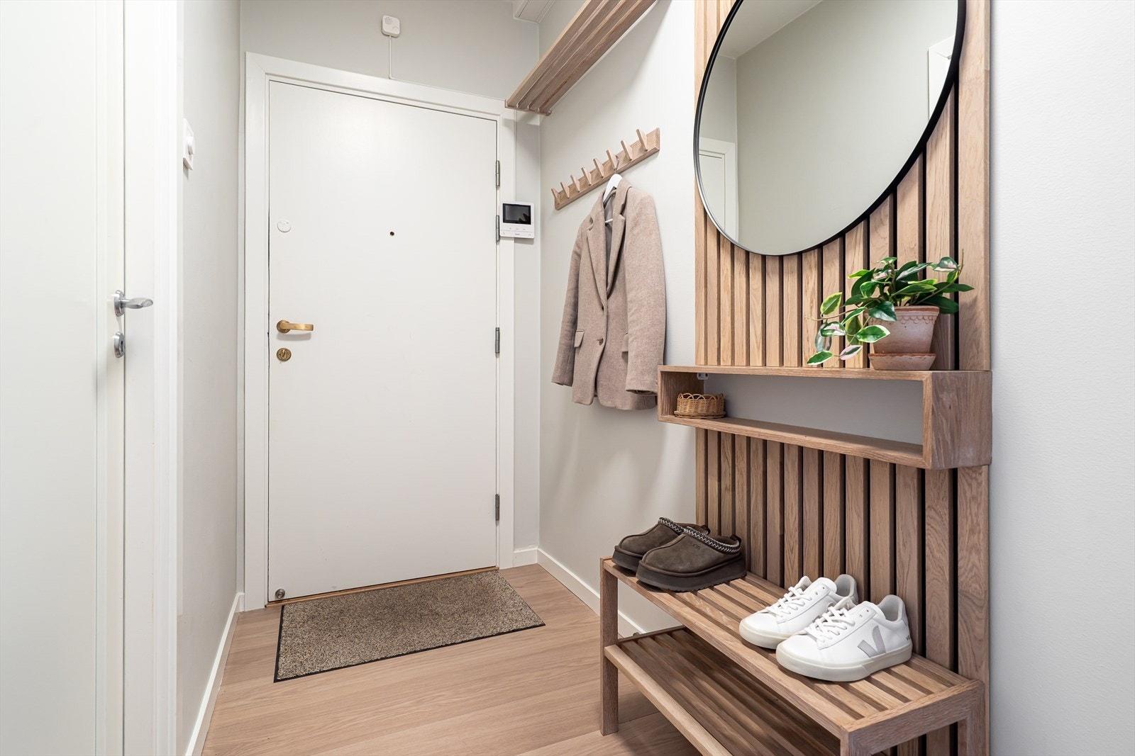Leiligheten har en innbydende entré med pent laminatgulv i imitert eik og plass til både sko og yttertøy. Galleribilde
