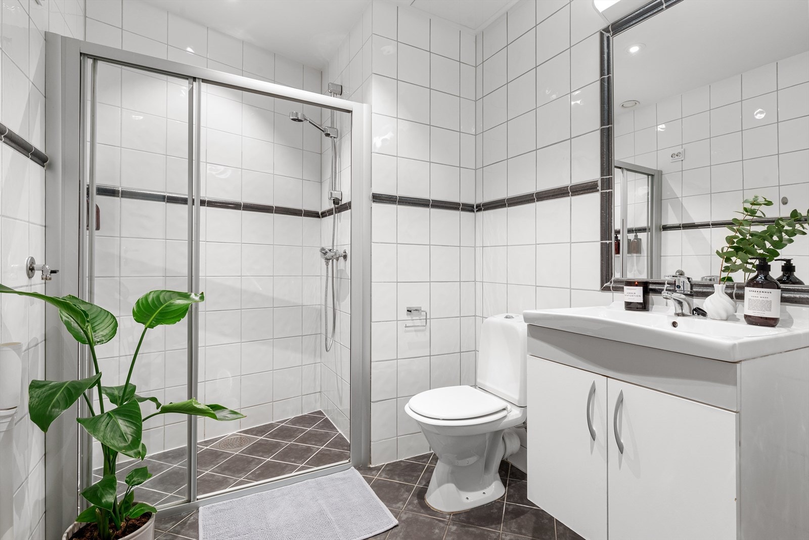 Stort bad med dusjnisje, wc, servant med underskap, speil og opplegg for vaskemaskin. Galleribilde