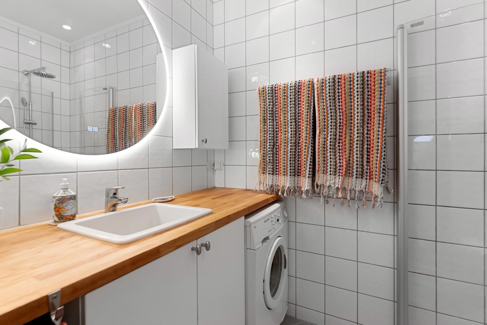 Plasstilpasset baderomsinnredning med heltre benkeplate og underskap. Nisje for vaskemaskin. Galleribilde