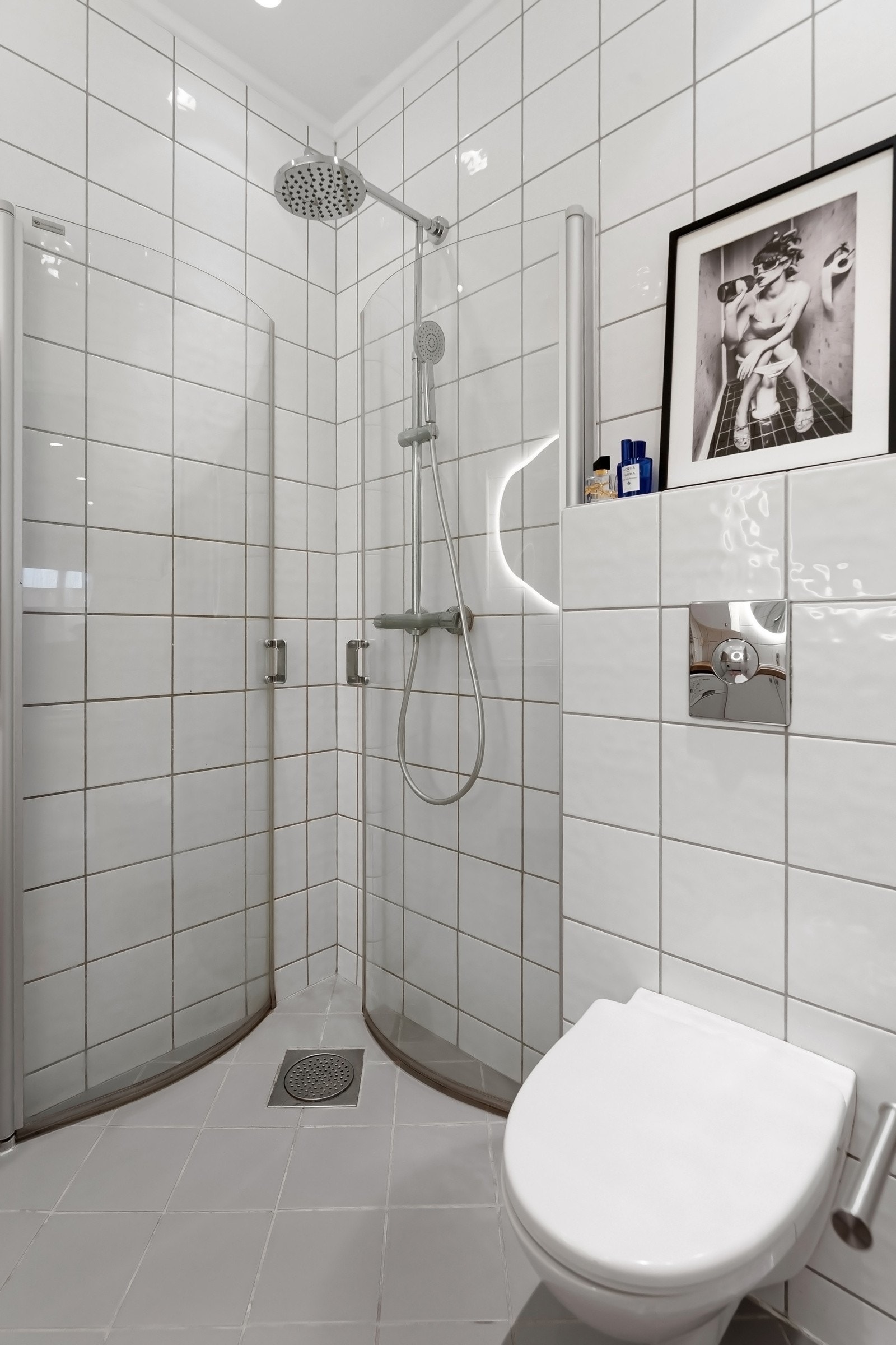 Dusjhjørne med innfellbare dusjdører i glass og vegghengt dusjgarnityr. Galleribilde