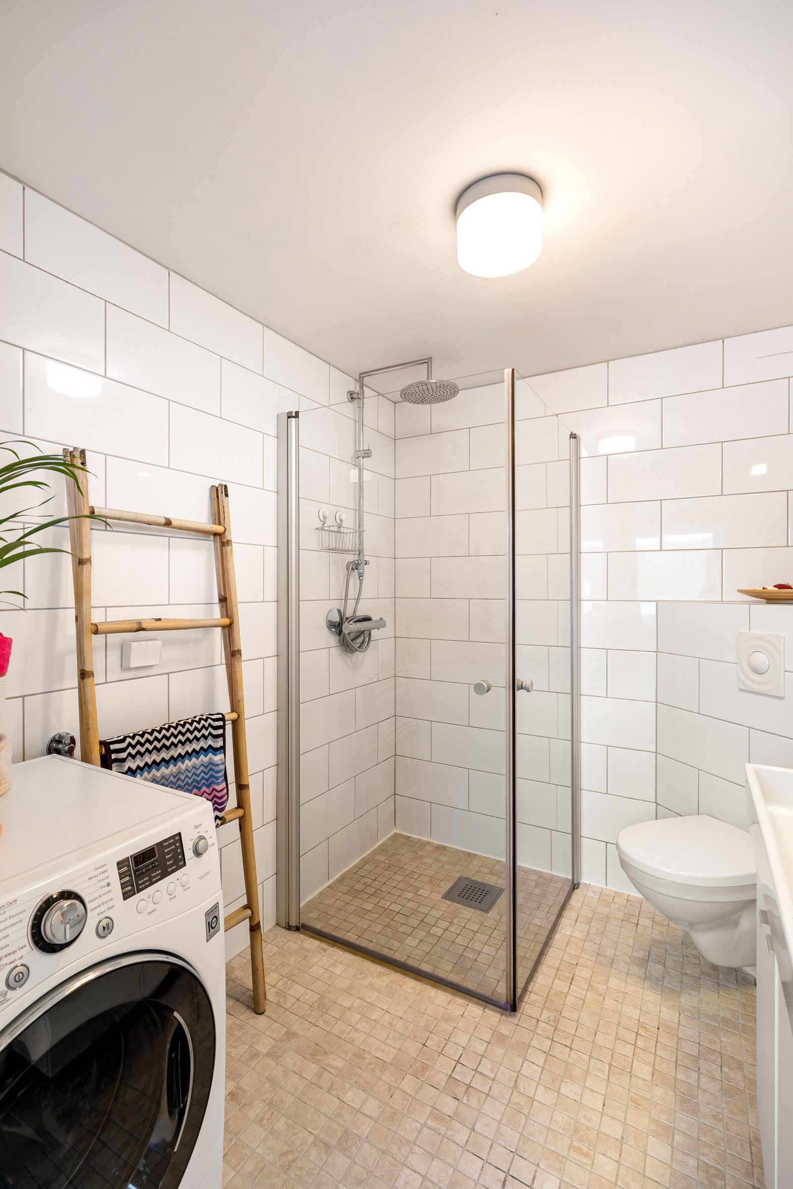 Badet er utstyrt med baderomsinnredning i hvit utførelse og med tilhørende speilskap, dusjnisje og vegghengt toalett. Galleribilde