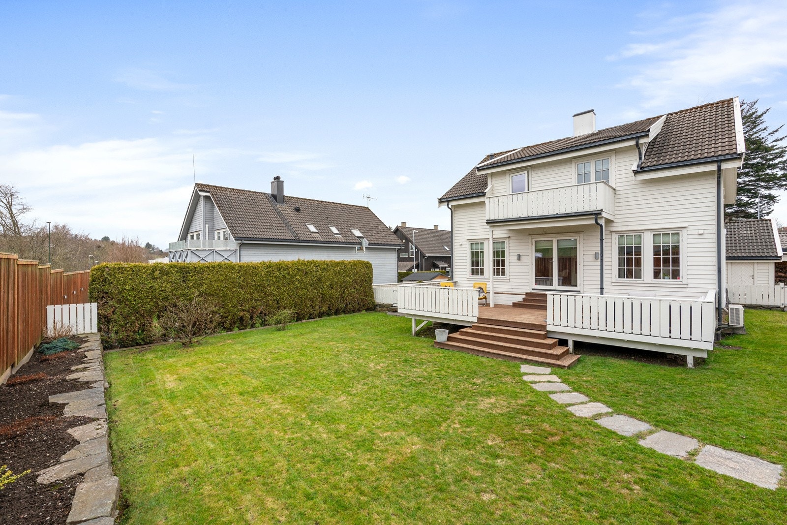 Tomten er pent opparbeidet med grøntareal, heller, terrasse og beplantning. Galleribilde