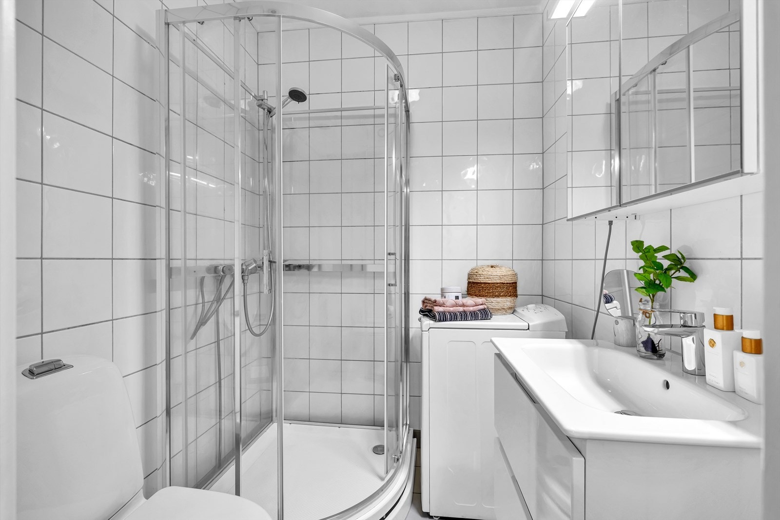 Boligens bad er fra 2001 med dusjkabinett, gulvstående klosett, servant med underskap samt overskap med speilfronter. Opplegg for vaskemaskin på badet Galleribilde