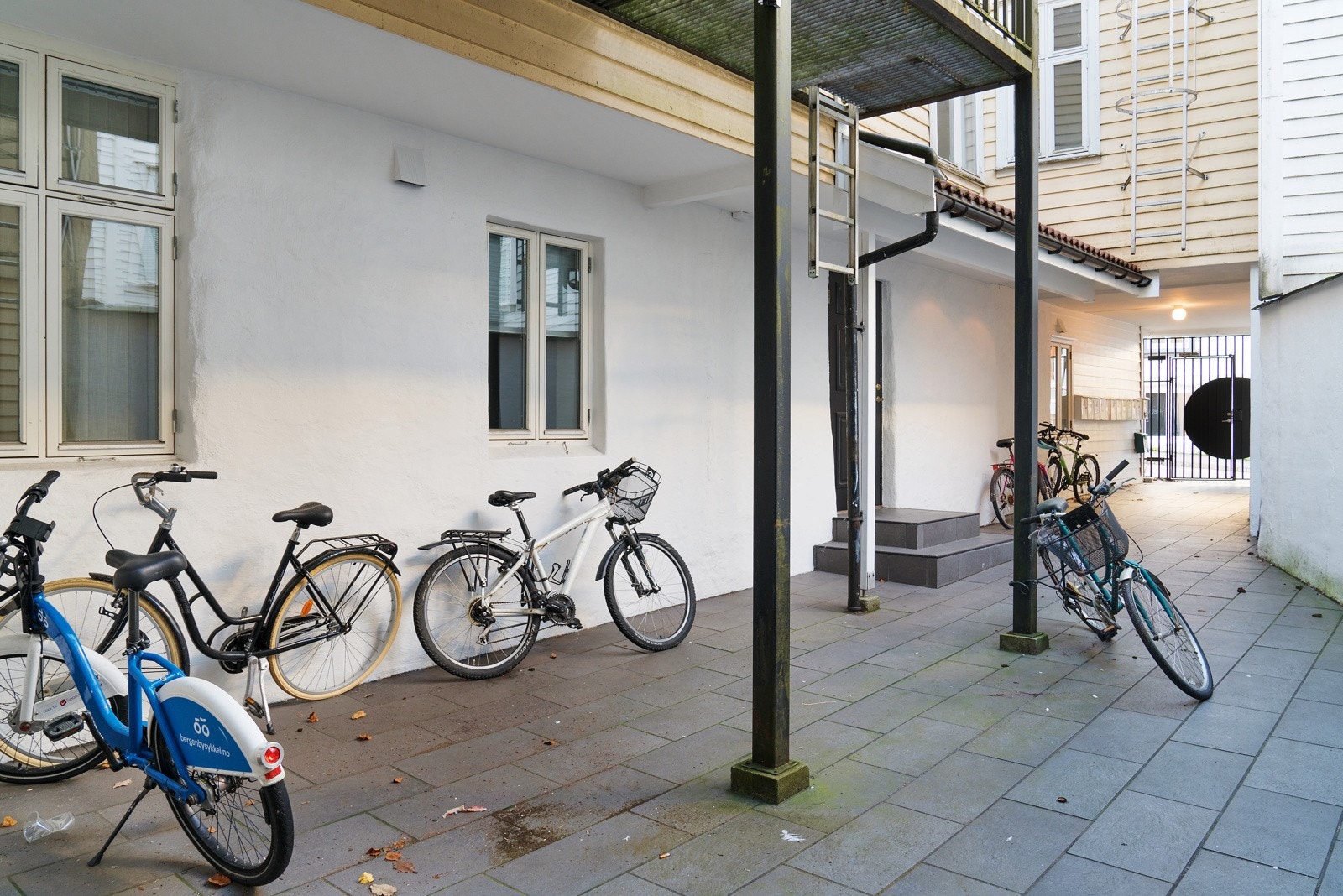 Det er port inn til den flislagte bakgården, som gjør det trygt å parkere syklene sine her. Galleribilde