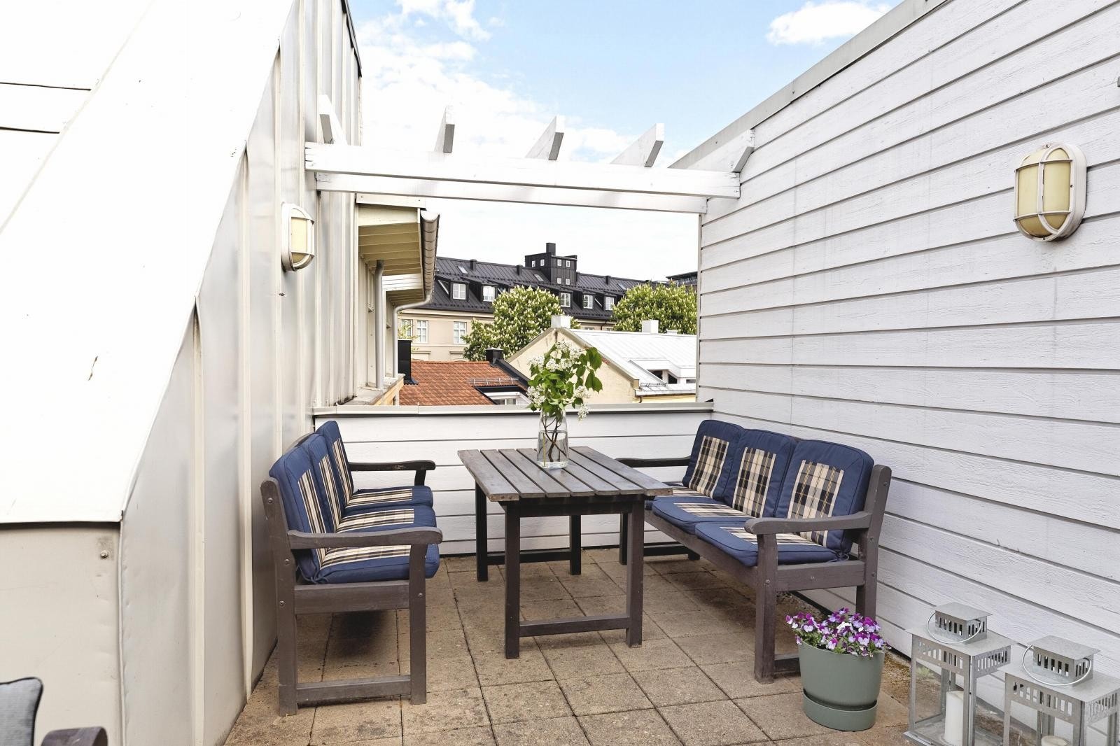 Takterrasen er utstyrt med utemøblement og grill Galleribilde