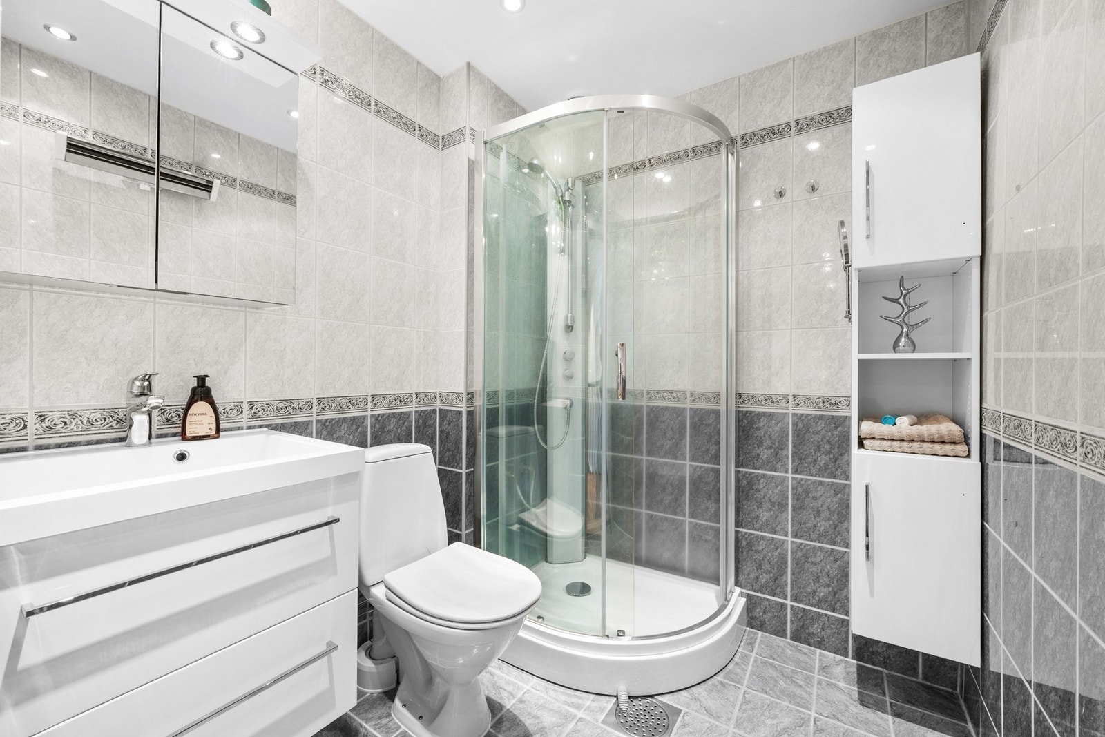 Innredningen har heldekkende servant, og det er i tillegg montert høyskap, samt dobbelt speilskap med belysning. Galleribilde