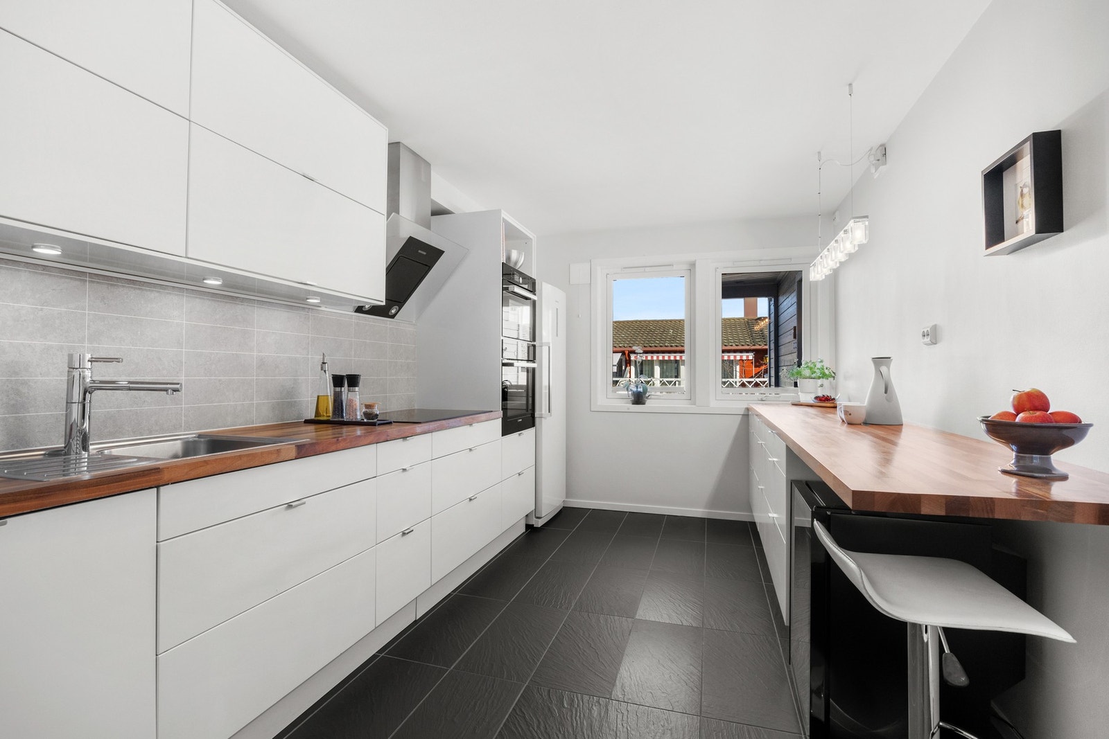 Kjøkkenet ligger i eget rom og har nyere Ikea-innredning med stilrent design. I benken er det nedfelt oppvaskkum og integrert induksjonstopp fra 2018 med ventilator over. Galleribilde