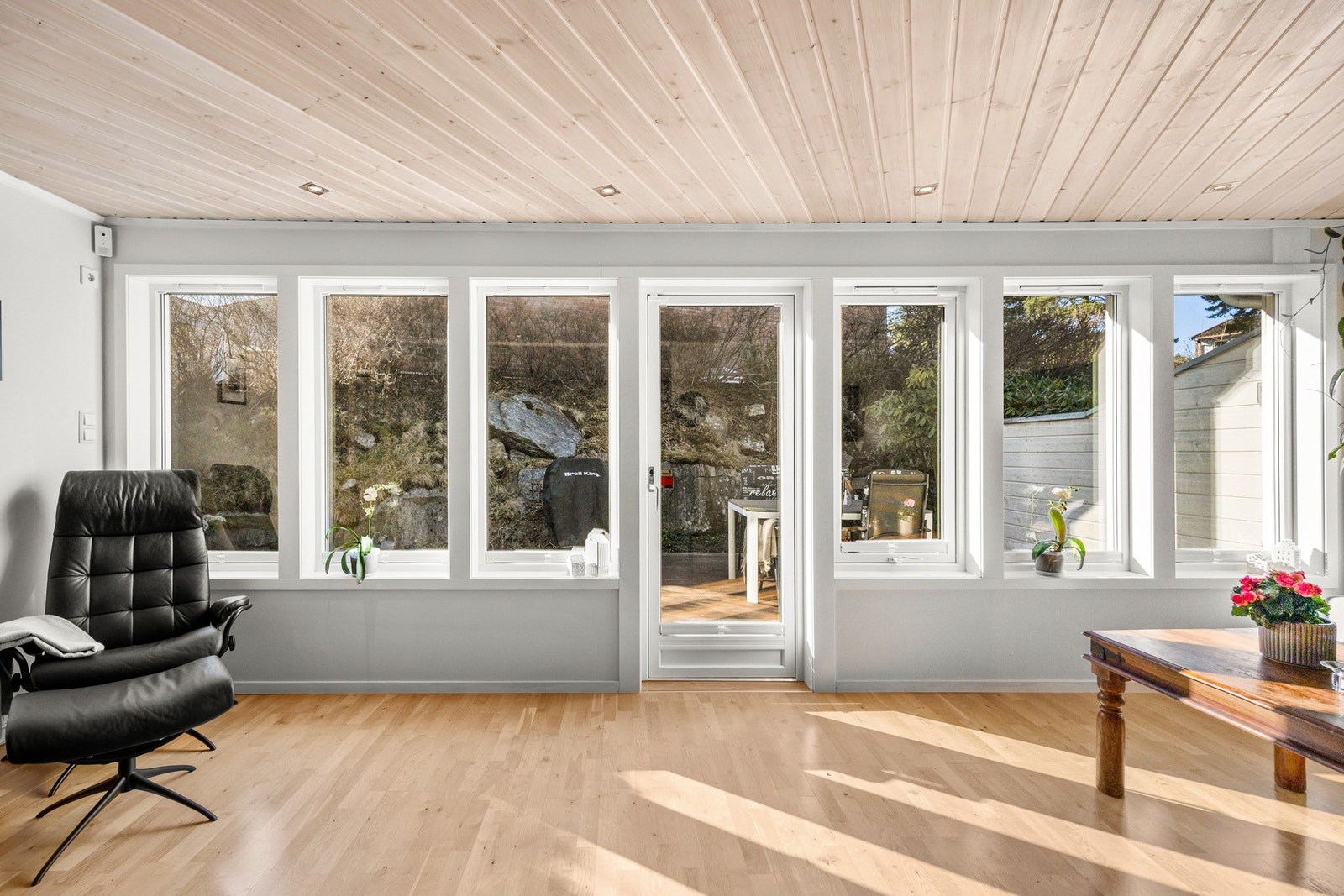 Langs hele sørveggen er det store vindusflater som slipper inn rikelig med dagslys og gir utsyn mot naturtomten. Galleribilde