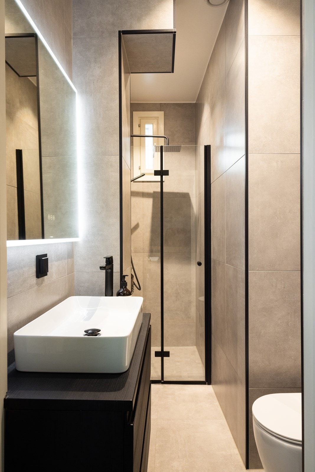 20250425-045A8354.jpgInnredningen består av dusjnisje, baderomsinnredning med speil og vegghengt toalett. Galleribilde