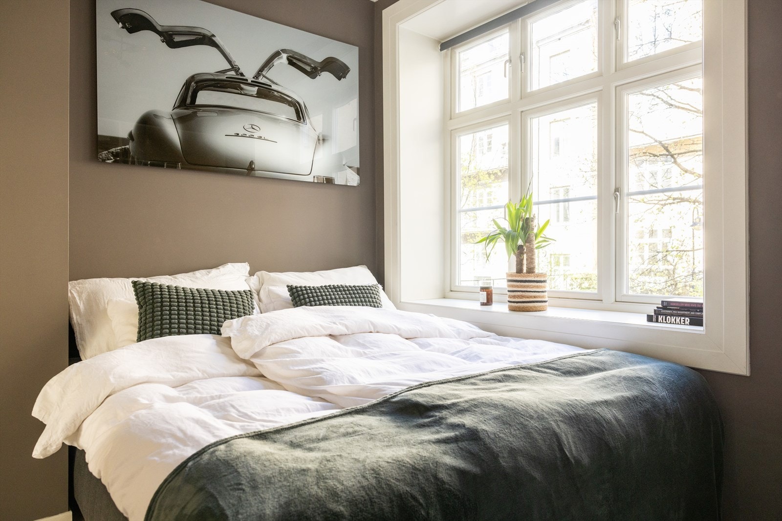 Leilighetens soverom har lyse vegger og malt, originalt tregulv. Galleribilde