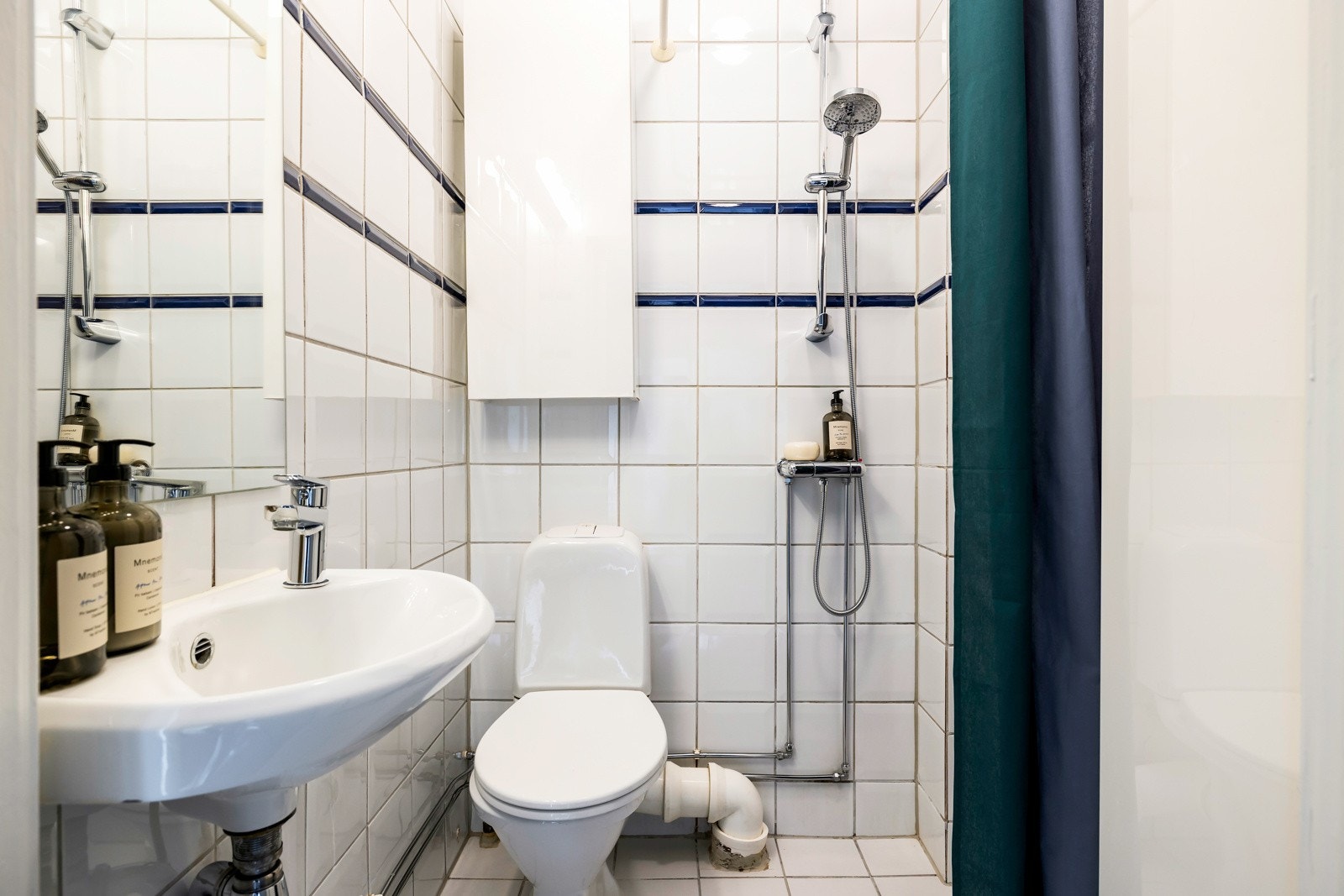 Badet er innredet med dusjhjørne, enkel servant og speil. Det er to vegghengte skap med plass til oppbevaring. Galleribilde