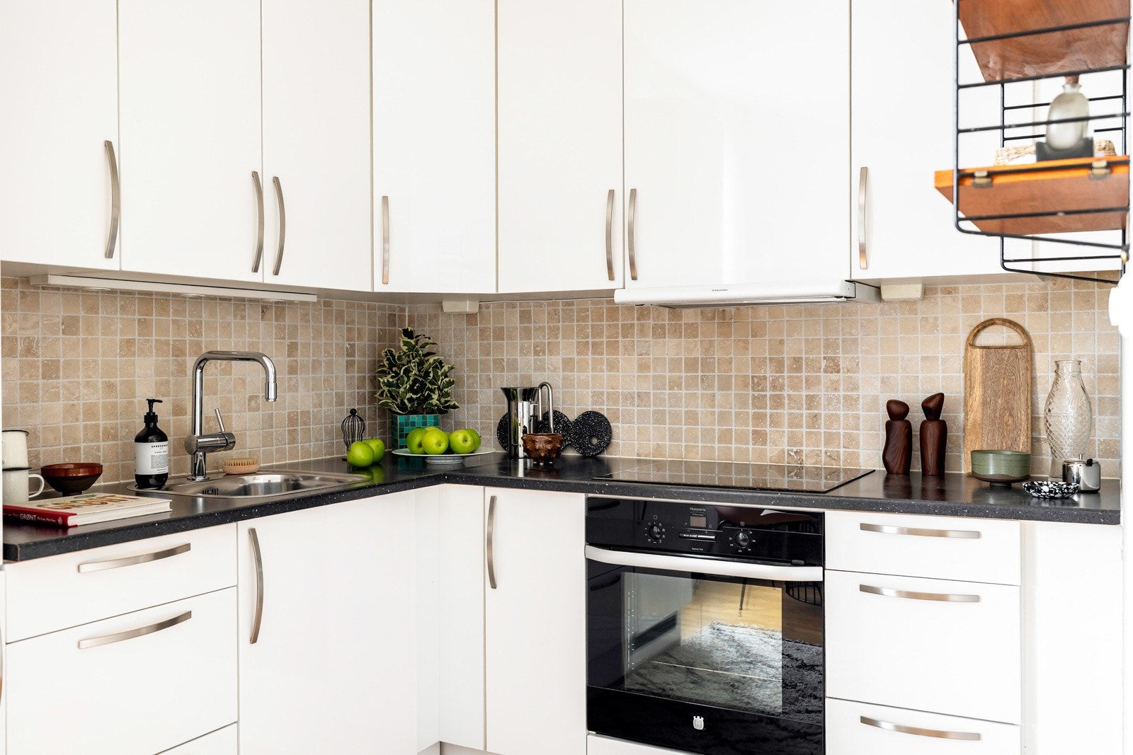 Benkeplaten er i laminat med nedfelt oppvaskkum, og det er fliser på veggen over benken. Galleribilde