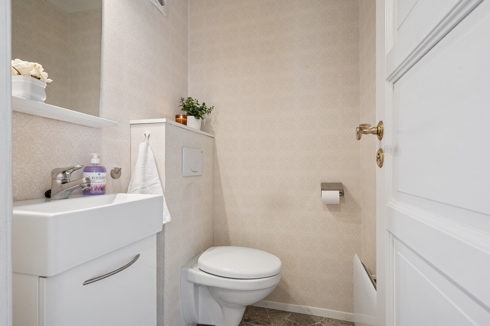 Toalettrom med vegghengt toalett og servant. Galleribilde