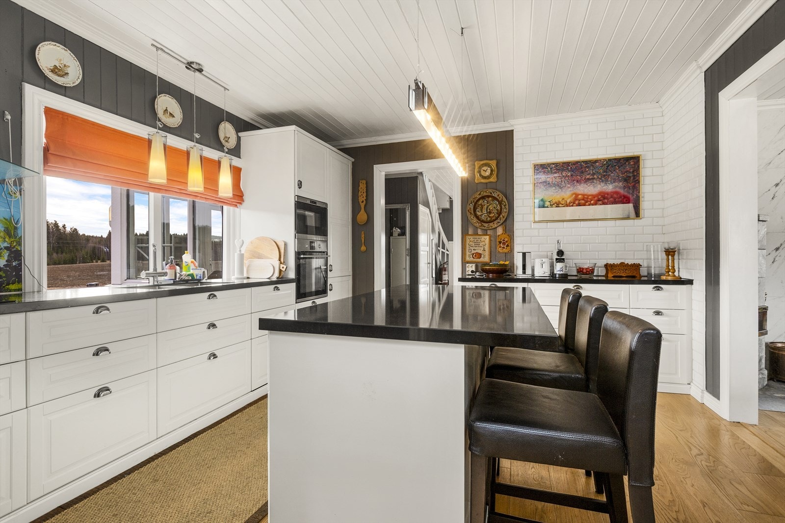 Kjøkkeninnredning med profilerte fronter og steinkompositt benkeplate. Galleribilde