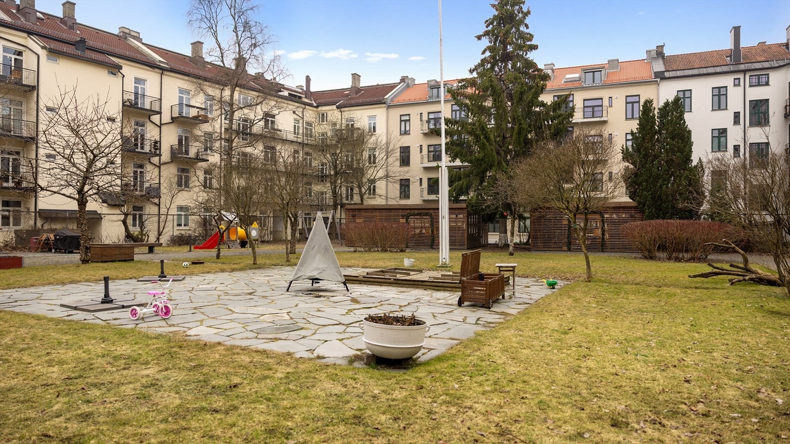 Frodig og idyllisk bakgård med sittegrupper, lekeplass og sykkelparkering Galleribilde