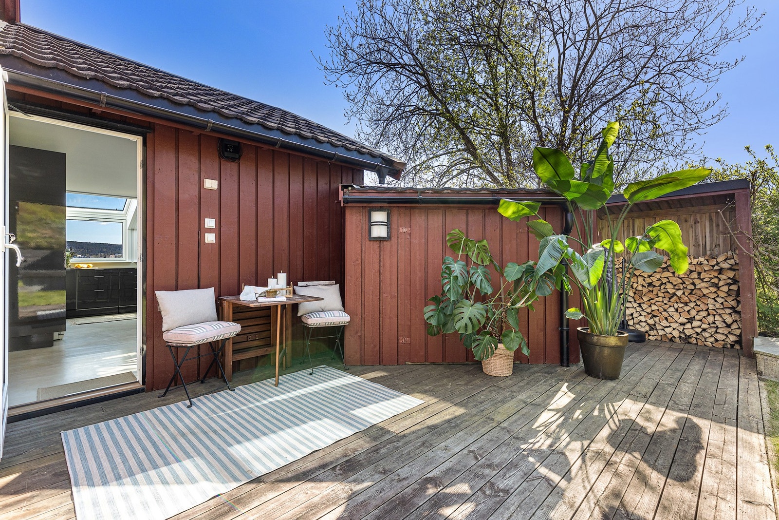 Utgang til hagen fra kjøkkenet. Legg merke til redskapsbod og vedskjul samt port mot trapp til framsiden av huset. Galleribilde