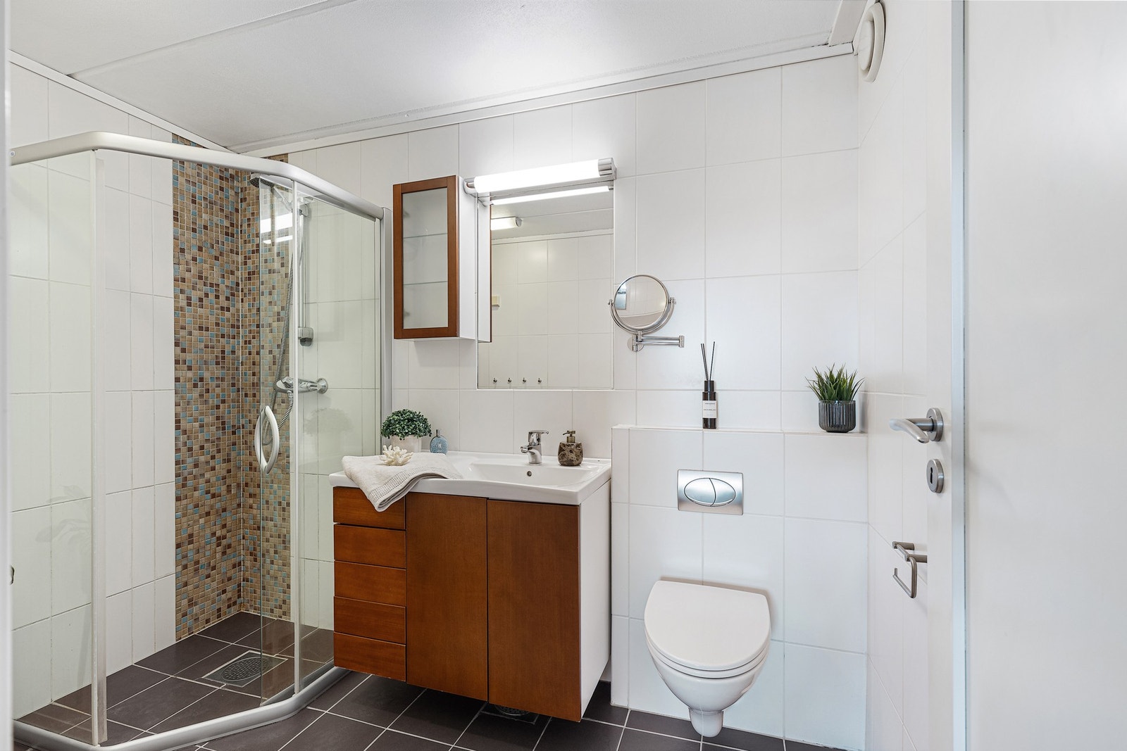 Pent, flislagt en-suite bad med gulvvarme, dusjnisje og vegghengt wc. Galleribilde