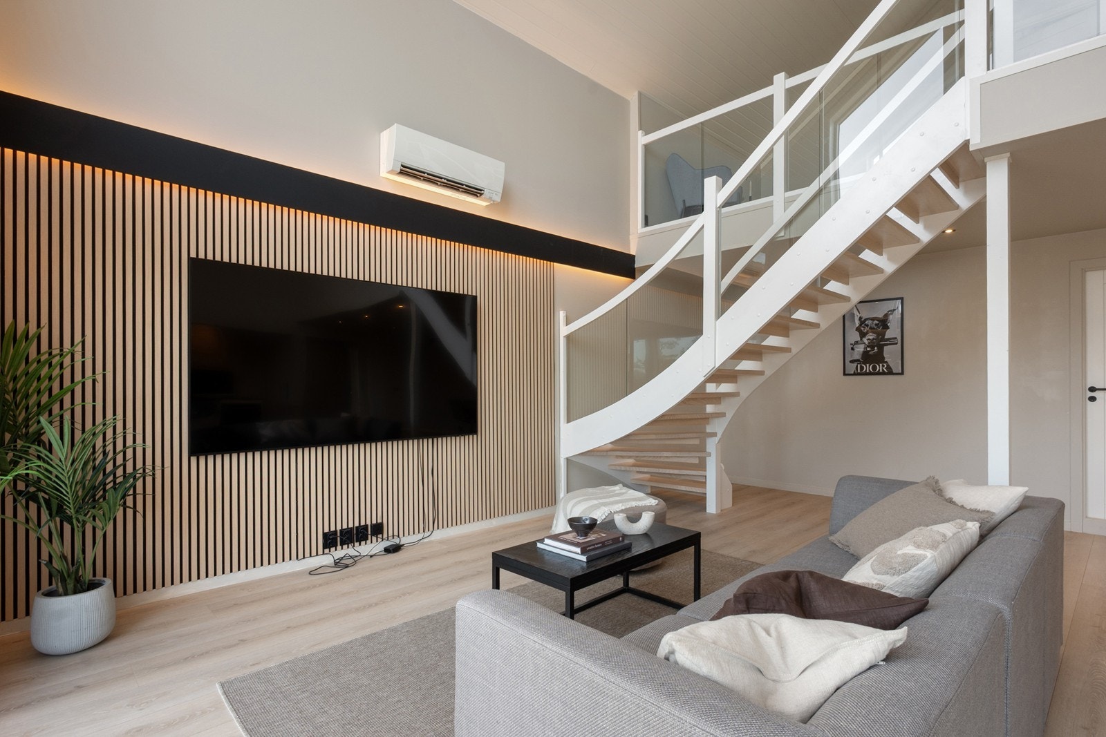 Stuen har en dekorativ spilevegg og det er godt med belysning i downlights og lyslister. Varmepumpen bidrar til jevn oppvarming hele året. Galleribilde