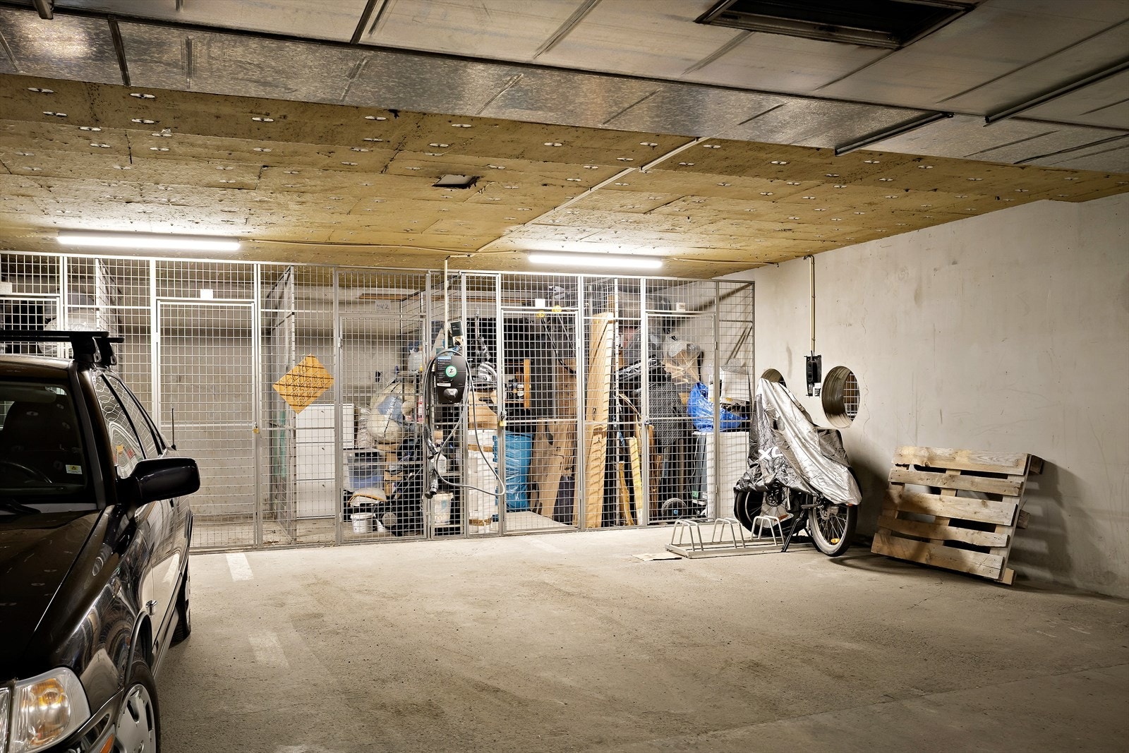 Leiligheten disponerer én garasjeplass med elbil-lader i felles garasjekjeller. Det medfølger bod til høyre bak garasjeplassen Galleribilde