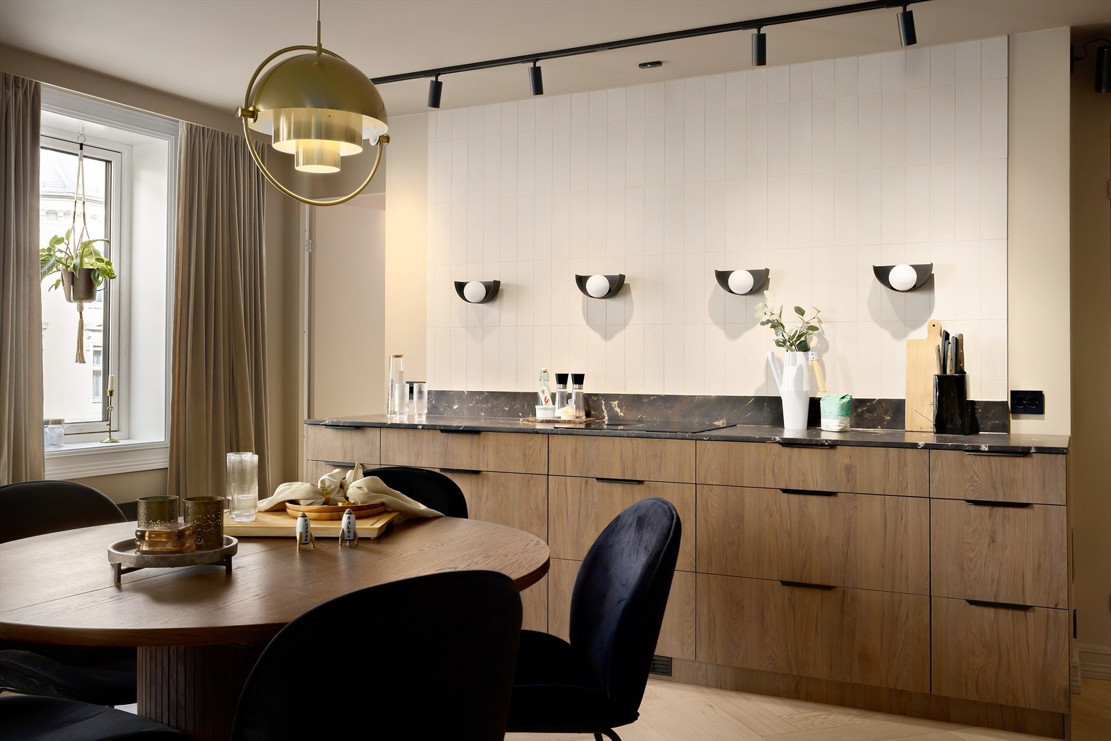 Plasseringen av kjøkkenet i leiligheten skaper en naturlig flyt mot stuen og gjør det enkelt å være sosial mens man lager mat. Galleribilde