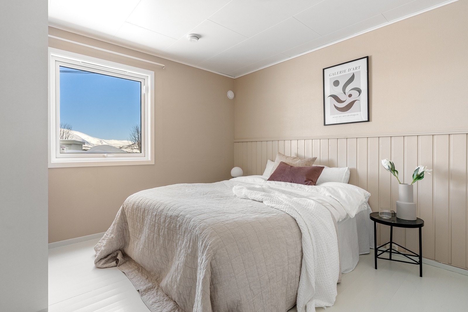 Boligens første soverom er beliggende i underetasjen og fremstår romslig med god plass for stor seng med tilhørende nattbord. Galleribilde