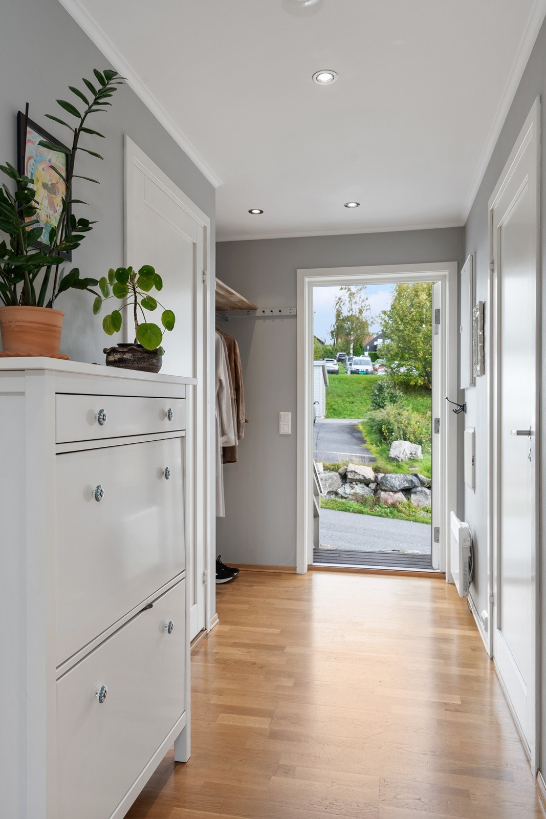 Lys og romslig entré/gang med plass for oppbevaring av yttertøy og sko, kommode og kneggrekker. Ekstra oppbevaringsmuligheter i bod. Galleribilde