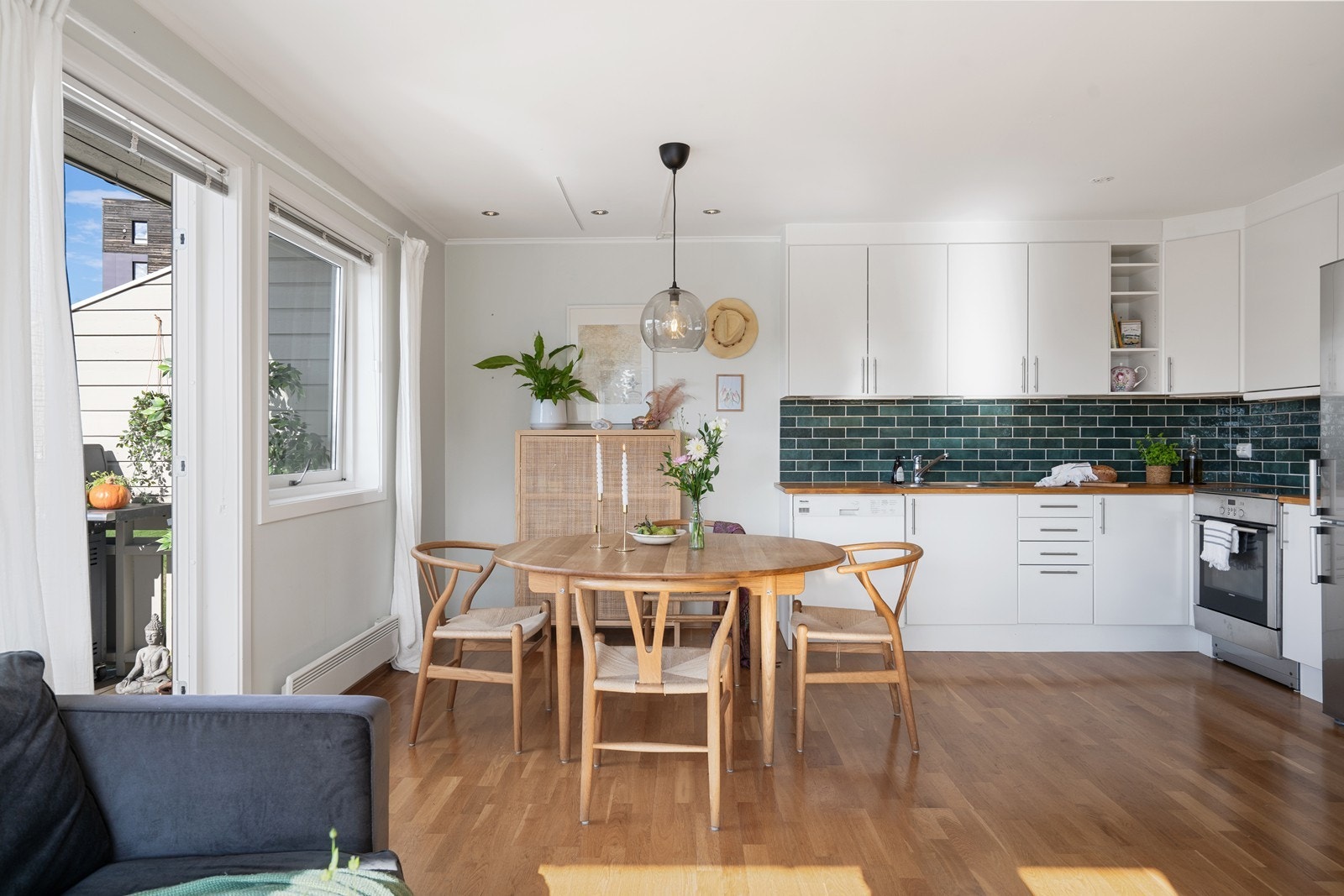 Stue med åpen kjøkkenløsning som er enkel å møblere med spiseplass, sofakrok, hyller og reoler. Galleribilde