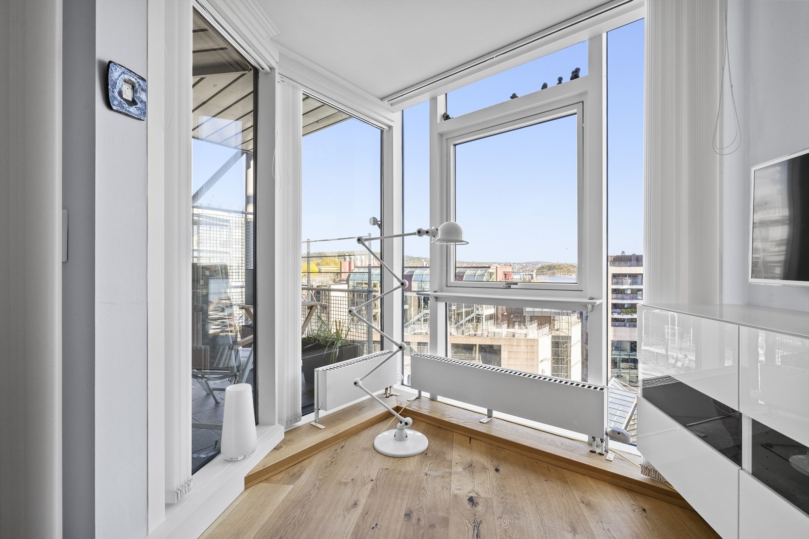 Koselig lesehjørne med utsikt mot torget og bassenget. I bakgrunn kan du skimte Akershus Festning. Galleribilde