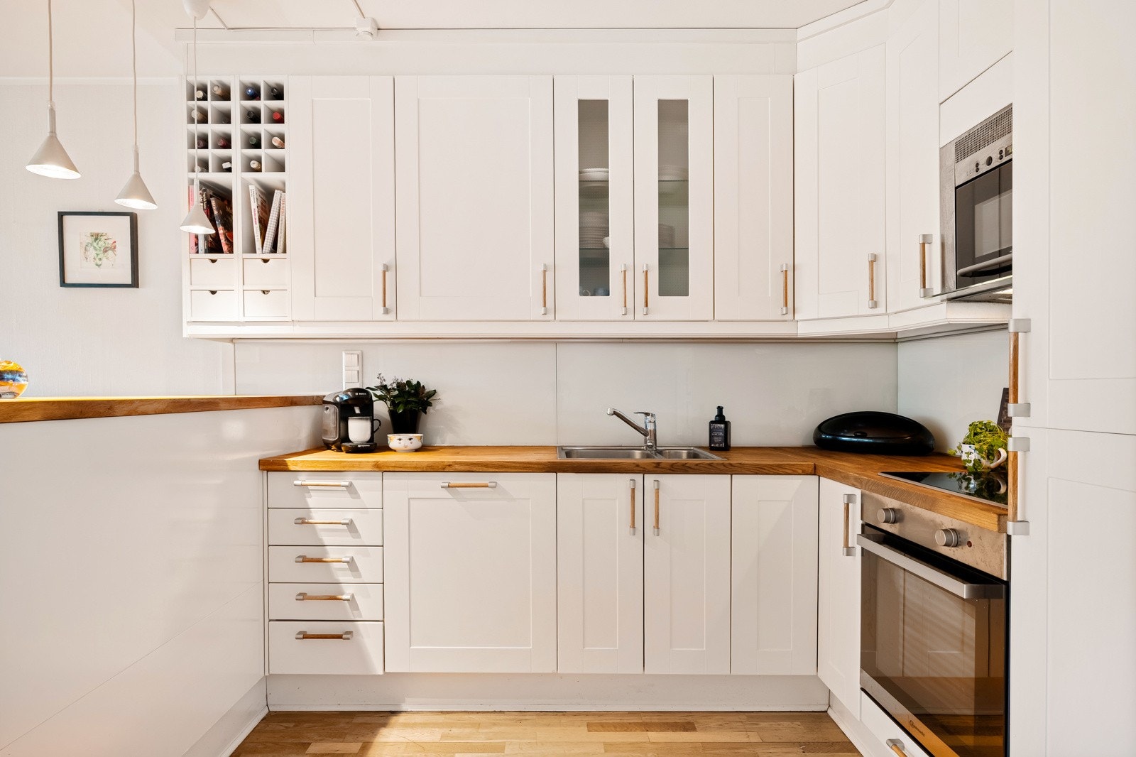 Kjøkkenet ligger noe tilbaketrukket i rommet og har en lys innredning med integrerte hvitevarer. Galleribilde