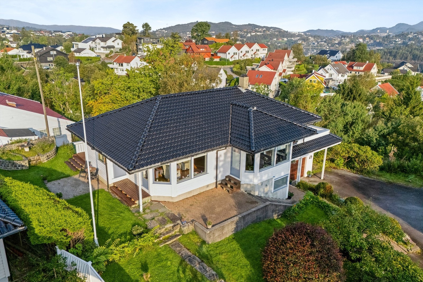 Stor og flott hage med flere solrike uteplasser. Pent opparbeidet med trær og prydbusker, bed og plenareal. Galleribilde