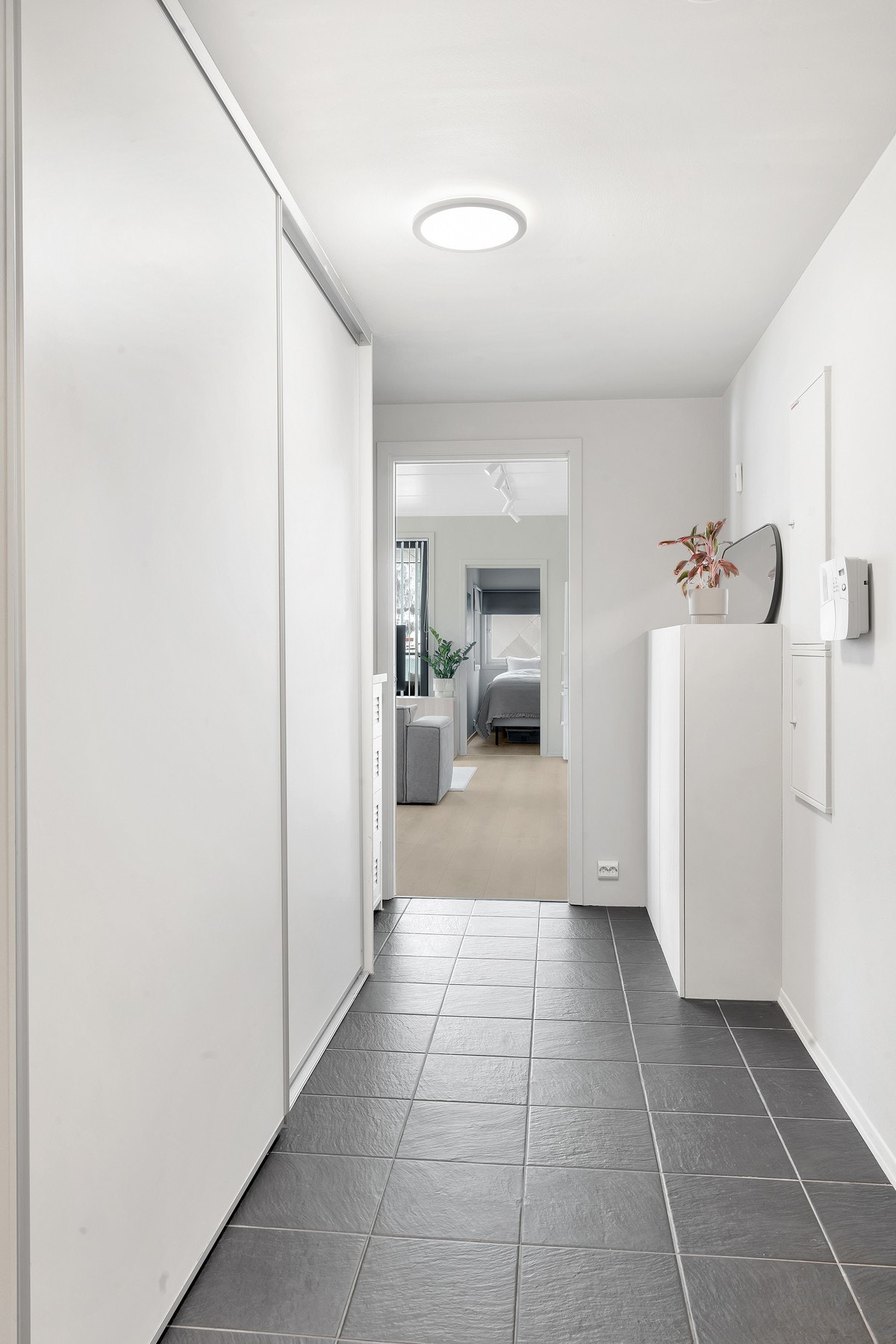 Velkommen inn i en hyggelig entre med en praktisk skyvedørsgarderobe og flislagt gulv med gulvvarme. Galleribilde