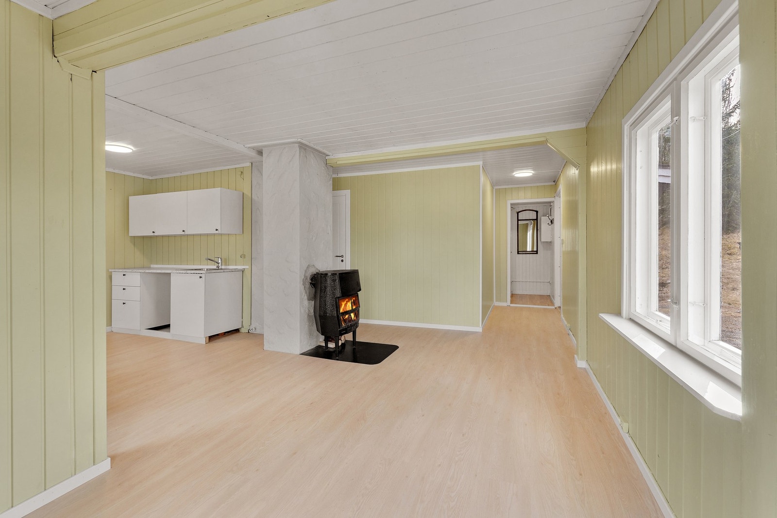 Stuen er av stor størrelse med store vinduer som slipper inn rikelig med naturlig lys Galleribilde