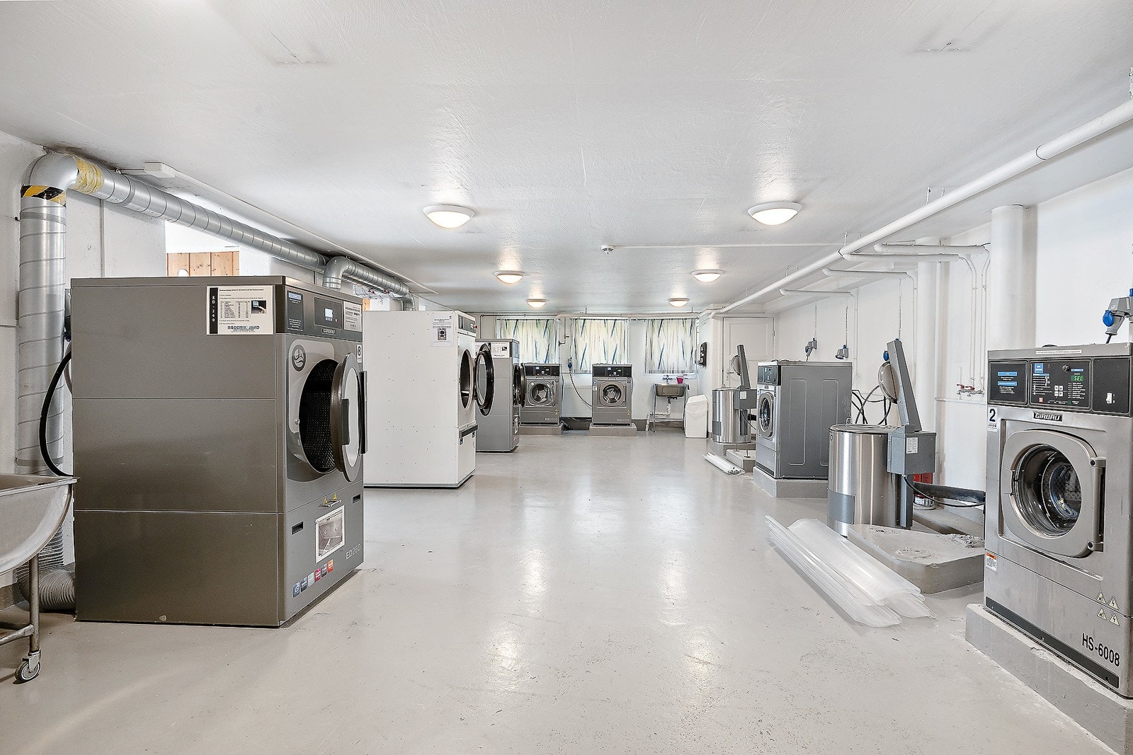 Fellesvaskeri med moderne vaskemaskiner og tørketromler med høy kapasitet Galleribilde