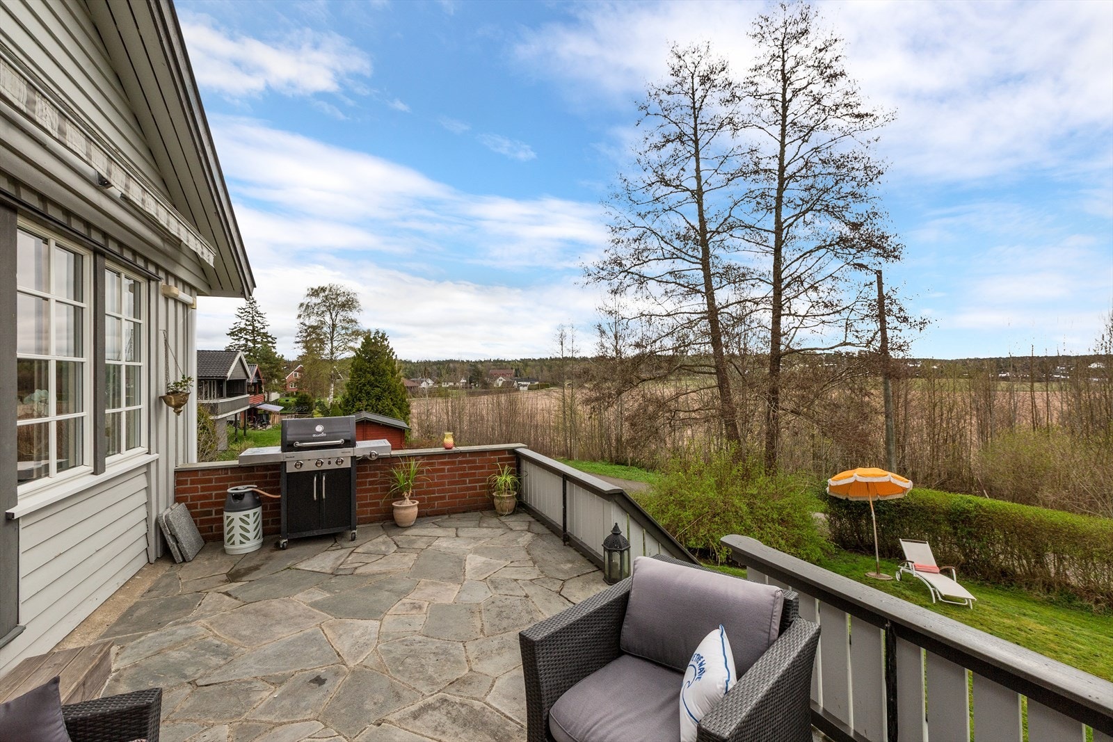 Fra veranda er det fin utsikt mot jorder og trapp ned til hagen Galleribilde