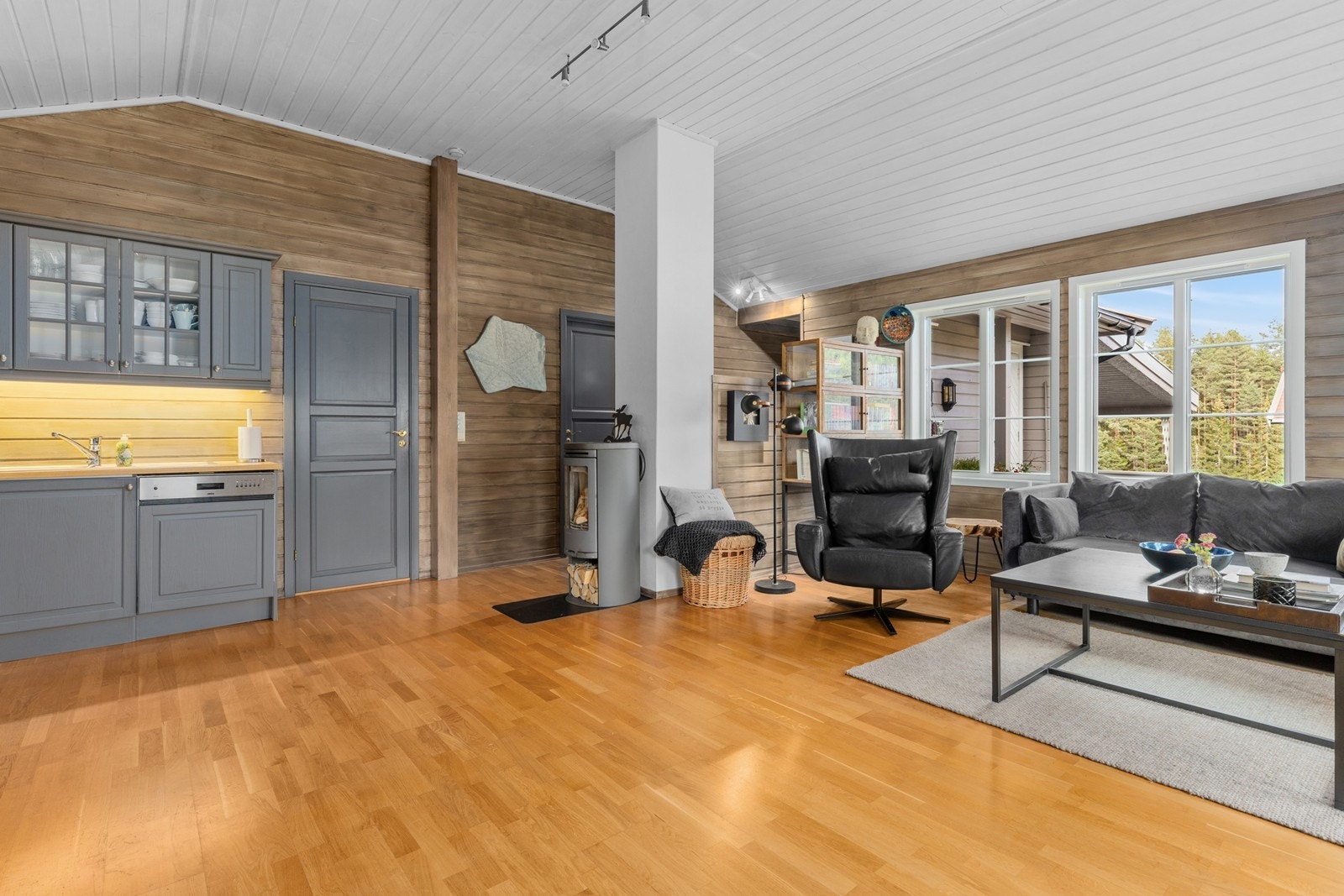 Lunt og koselig med beiset panel på vegger, og peisovn Galleribilde