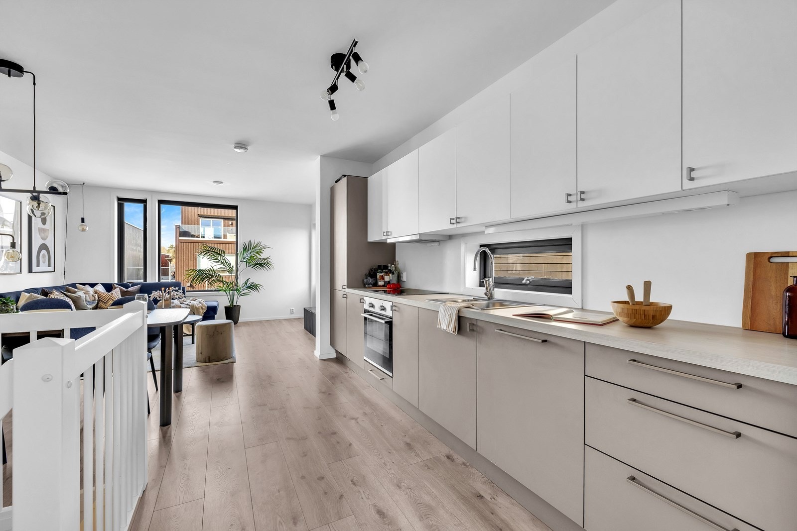 Moderne kjøkken med integrerte hvitevarer og plass til spisebord. Galleribilde